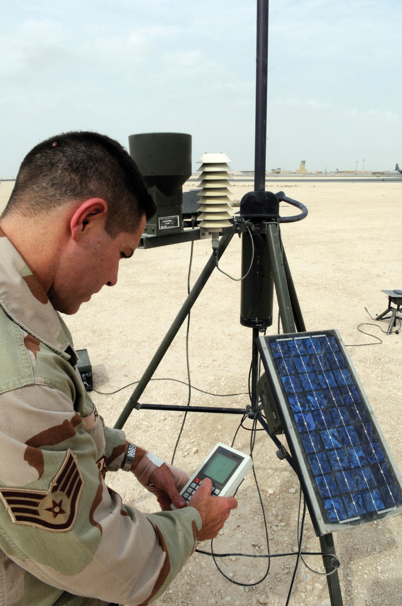 Staff Sgt. Kevin Fedon, weather forecaster assigned to the 379th Expeditionary Operations Support Squadron, checks weather readouts (temperature, wind speed/direction and precipitation) at a remote weather sensor at an undisclosed location in Southwest Asia Nov. 4, 2008. The weather readings are put into a weather model to help predict weather patterns and are used for daily reports to aircrews preparing for missions.  Sergeant Fedon is a native of Lincoln, Neb., and is deployed from the Nebraska Air National Guard out of Offutt Air Force Base, Neb.  (U.S. Air Force photo by Tech. Sgt. Michael Boquette)