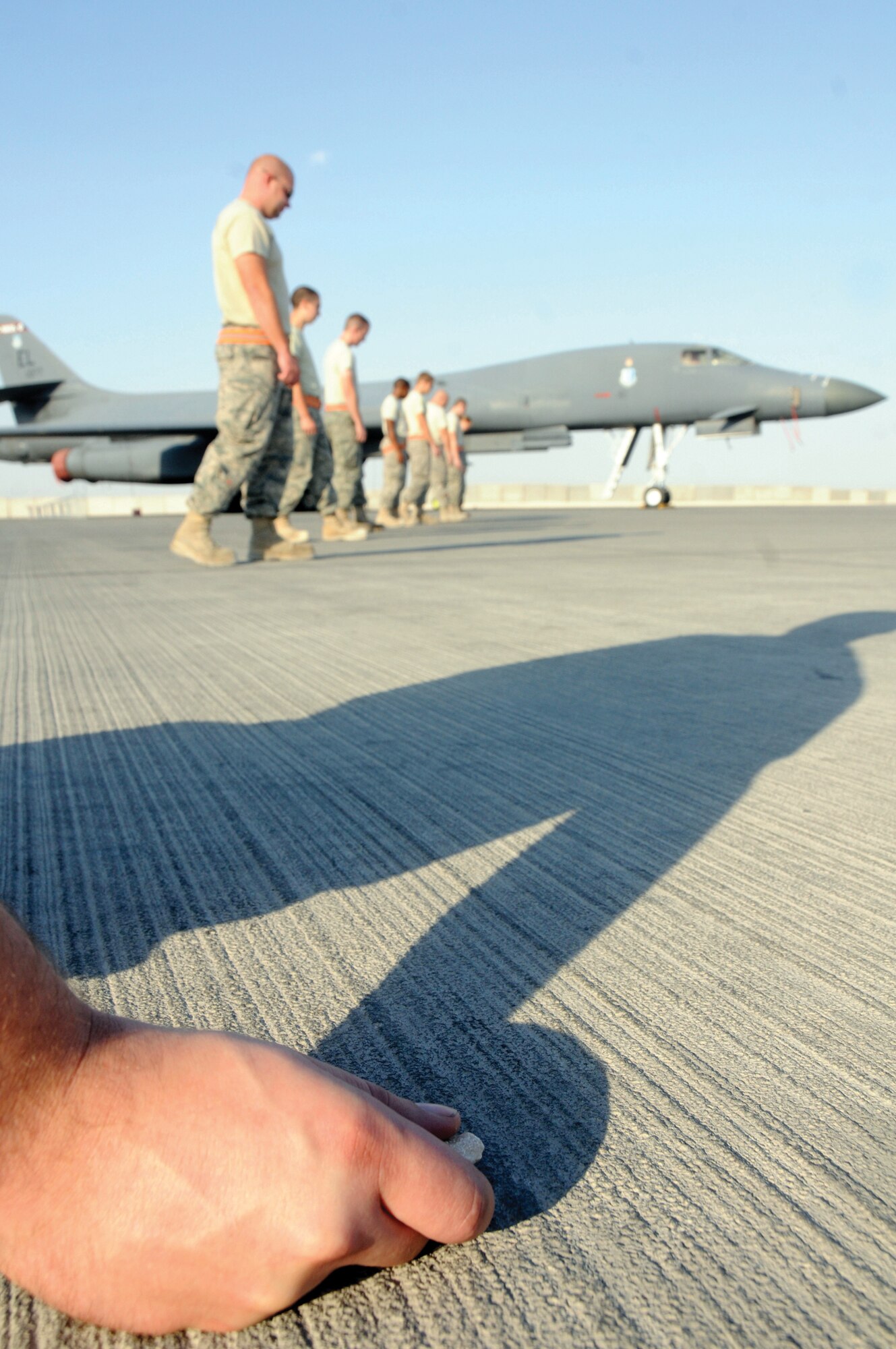 Members of the 34th Aircraft Maintenance Unit conduct a foreign object debris walk at an undisclosed location in Southwest Asia. A FOD walk is used to remove FOD from the flight line and the 34th AMU conducts two FOD walks each day. (U.S. Air Force photo by Staff Sgt. Darnell T. Cannady)