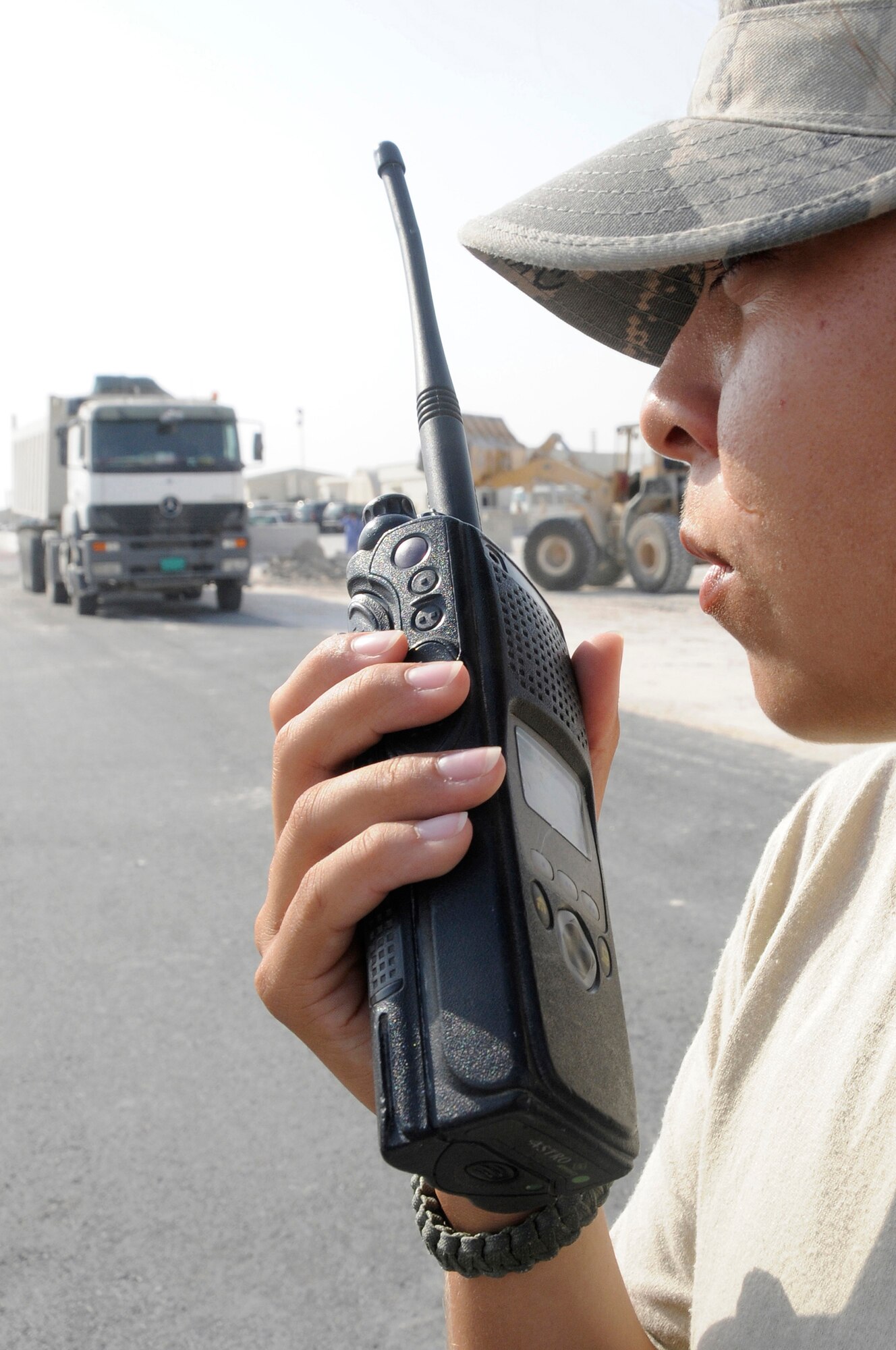 Senior Airman Brenna Reynolds, escort assigned to the 379th Expeditionary Civil Engineer Squadron, uses her radio to call in for accountability Nov. 13, at an undisclosed air base in Southwest Asia. The 379 ECES escort members stay vigilant to ensure third country national contractors here complete their jobs and don?t perform any acts that would endanger deployed members. Airman Reynolds, a native of Van Horn, Texas, is deployed from Shaw Air Force Base, S.C., in support of Operations Iraqi and Enduring Freedom and Joint Task Force-Horn of Africa. (U.S. Air Force photo by Staff Sgt. Darnell T. Cannady/Released)