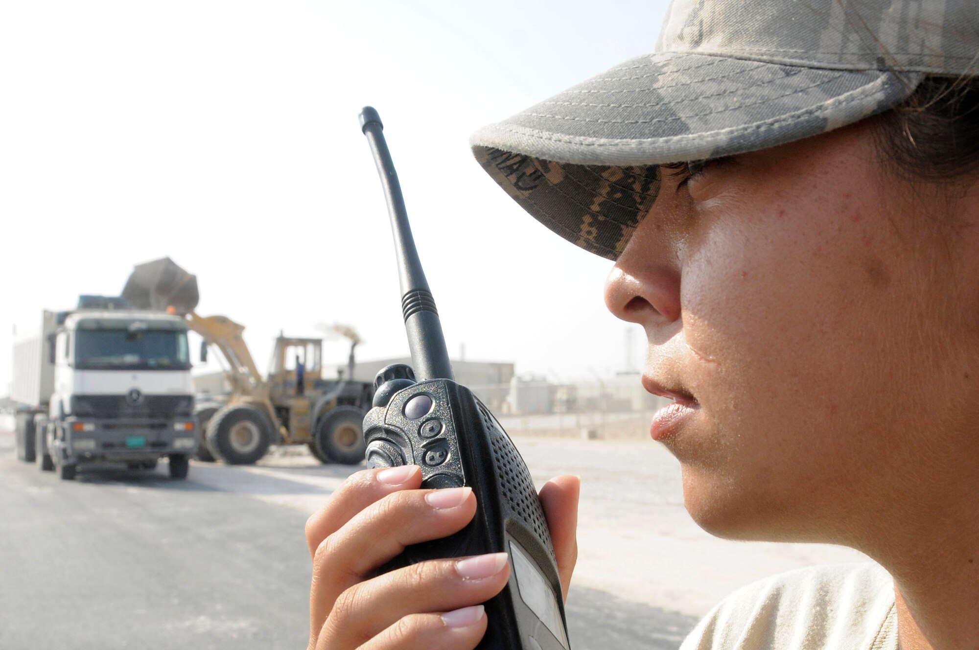 Senior Airman Brenna Reynolds, escort assigned to the 379th Expeditionary Civil Engineer Squadron, uses her radio to call in for accountability Nov. 13, at an undisclosed air base in Southwest Asia. The 379 ECES escort members stay vigilant to ensure third country national contractors here complete their jobs and don?t perform any acts that would endanger deployed members. Airman Reynolds, a native of Van Horn, Texas, is deployed from Shaw Air Force Base, S.C., in support of Operations Iraqi and Enduring Freedom and Joint Task Force-Horn of Africa. (U.S. Air Force photo by Staff Sgt. Darnell T. Cannady/Released)