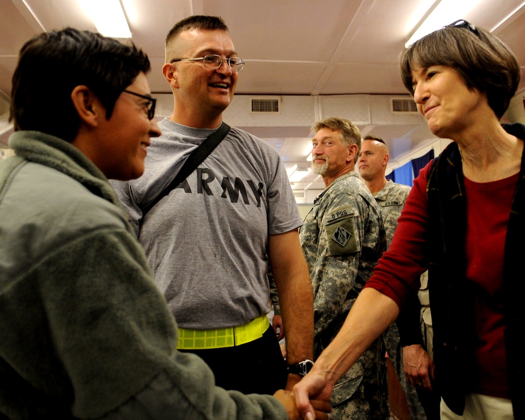 Sandee Cartwright, wife of Vice Chairman of the Joint Chiefs of Staff U.S. Marine Gen. James E. Cartwright, hands her husband's coin to U.S. Army Spc. Sophia Regino and Pfc. David Pearce during a visit to Forward Operating Base Fenty, Afghanistan, Nov. 13, 2008.