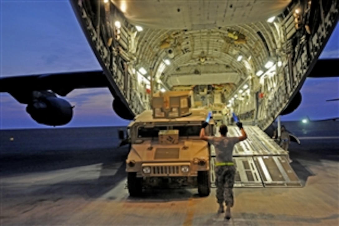 A U.S. Air Force airman guides a fully armored high mobility multipurpose wheeled vehicle onto a C-17 Globemaster III aircraft at an air base in Southwest Asia, Nov. 5, 2008. The airman is assigned to the 8th Expeditionary Air Mobility Squadron.