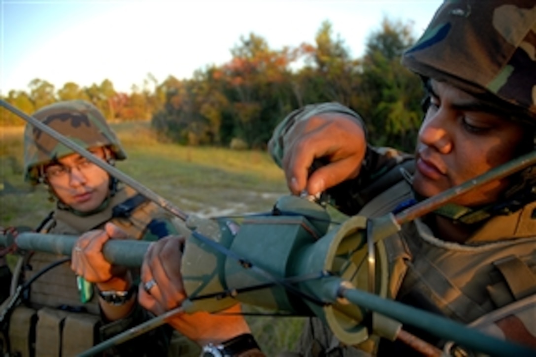 U.S. Navy Petty Officer 3rd Class Noe Lujan, right, and Petty Officer 2nd Class Anthony Arcilla  erect an OE-254 antenna at the system-tactical communications center at Forward Operating Base Zero at Camp Shelby, Miss., Nov. 3., 2008.  The sailors are assigned to Naval Mobile Construction Battalion 1.