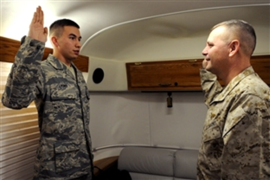 Vice Chairman of the Joint Chiefs of Staff U.S. Marine Gen. James E. Cartwright re-enlists U.S. Air Force Staff Sgt. Thomas Lyons in an executive compartment aboard a C-17 over Afghanistan, Nov. 13, 2008. Lyons is a C-17 crew chief assigned to the 305th Aircraft Maintenance Squadron at McGuire Air Force Base, N.J.