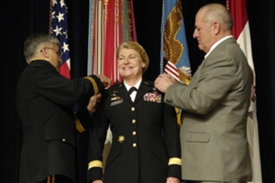 U.S. Army Lt. Gen. Ann E. Dunwoody smiles during her promotion to general, where she was pinned by Chief of Staff of the Army Gen. George W. Casey, left, and her husband, Craig Brotchie, during a ceremony at the Pentagon, Nov. 14, 2008.  Dunwoody made history as the nation's first four-star female officer.