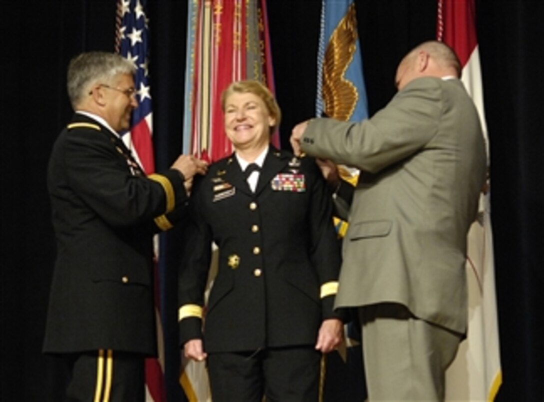 U.S. Army Lt. Gen. Ann E. Dunwoody (center) smiles as Chief of Staff of the Army Gen. George W. Casey (left) and her husband, Craig Brotchie, pin the rank of general on her during her promotion ceremony in the Pentagon on Nov. 14, 2008.  Dunwoody is the first female in the U.S. military to achieve the rank of four-star general.  