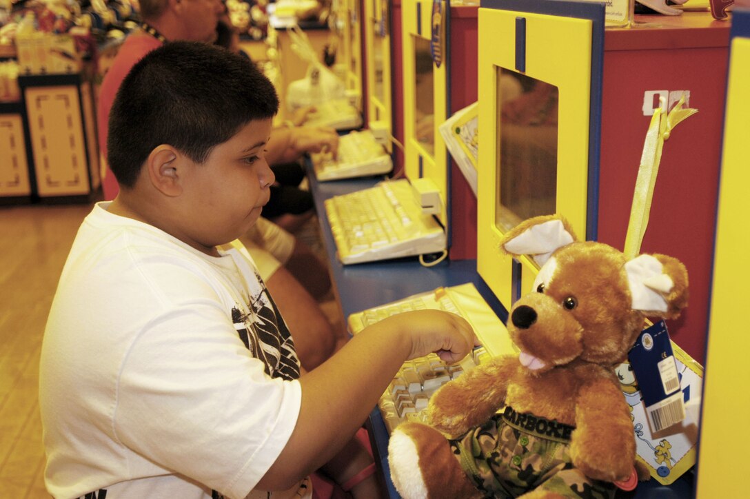 Costas Rodrigues, 7, names the plush animal he created, 'Costas,' after himself, for donation to the Marine Corps Reserve's annual Toys for Tots drive at the Ala Moana Build-a-Bear Workshop Nov. 15. 'I know they will be happy to have the toy and play with it,' said Costas about the child who will receive his gift.