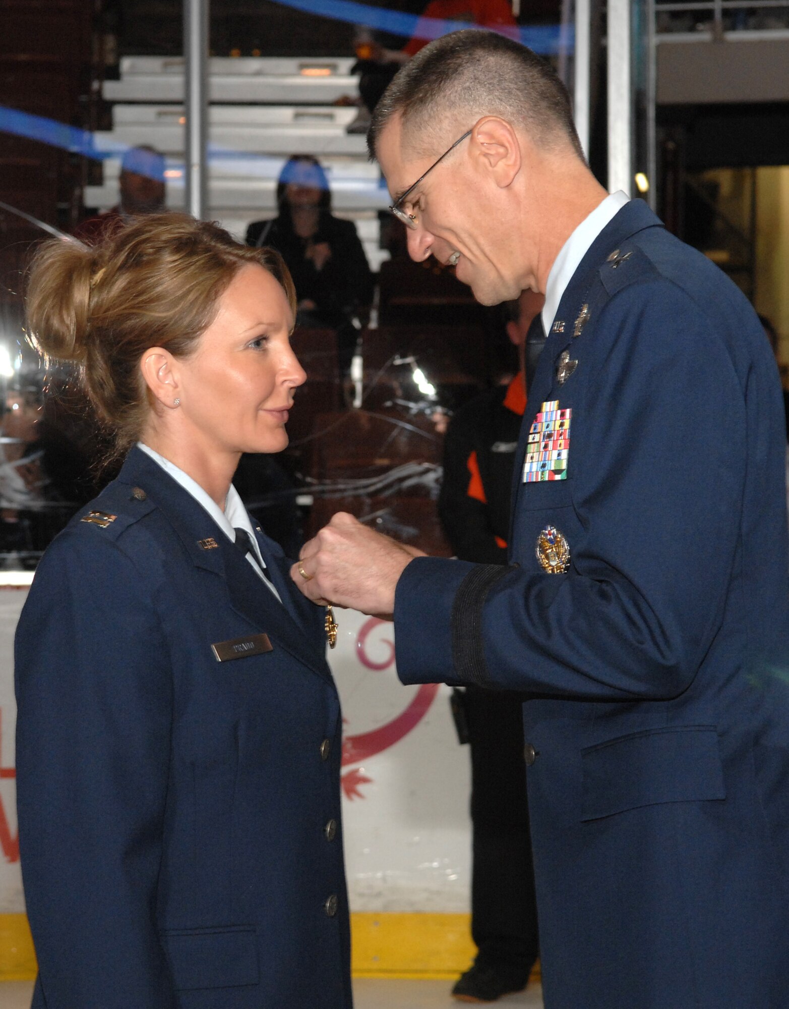 U.S. Air Force Brig. Gen. Jay G. Santee, vice commander, 14th Air Force, Air Force Strategic-Space, pins the Joint Service Commendation Medal on Capt. Angela C. Prado at the Honda Center before a Ducks vs Predators hockey game in Anaheim, Calif.  during Air Force Week Nov. 14.