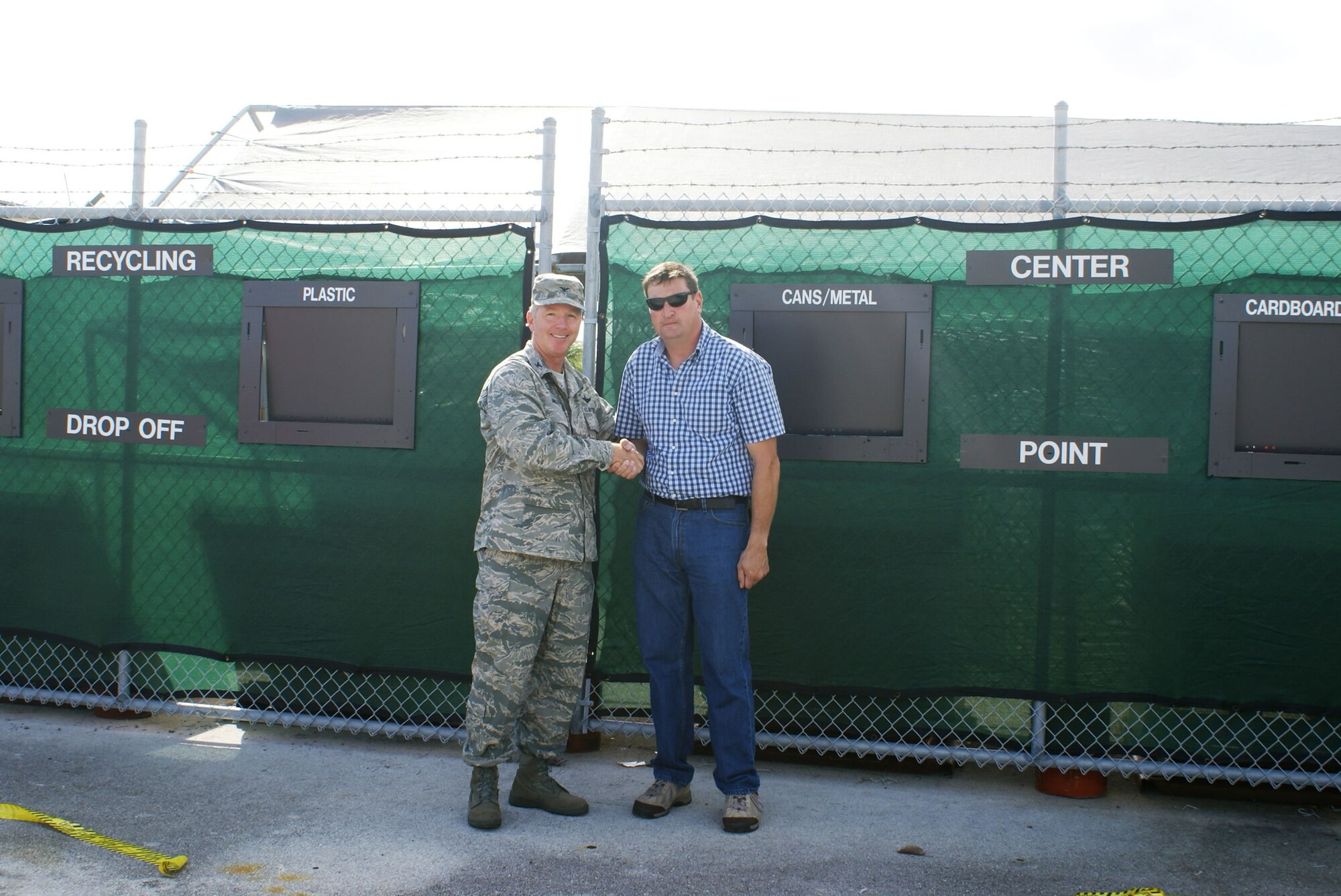 Col. William B. Binger, 482nd Fighter Wing commander and Mr. Timothy Driscoll, 482nd FW Solid Waste Manager, open the new 24-hour recycled material accumulation point after a brief ceremony on Nov. 14.  As part of the America Recycles Day celebrations, Nov. 15, base personnel will now have a convenient way to dispose of their work place and home recyclables such as: paper, cardboard, plastic and aluminum cans. (U.S. Air Force photo/Nelly Veneros)