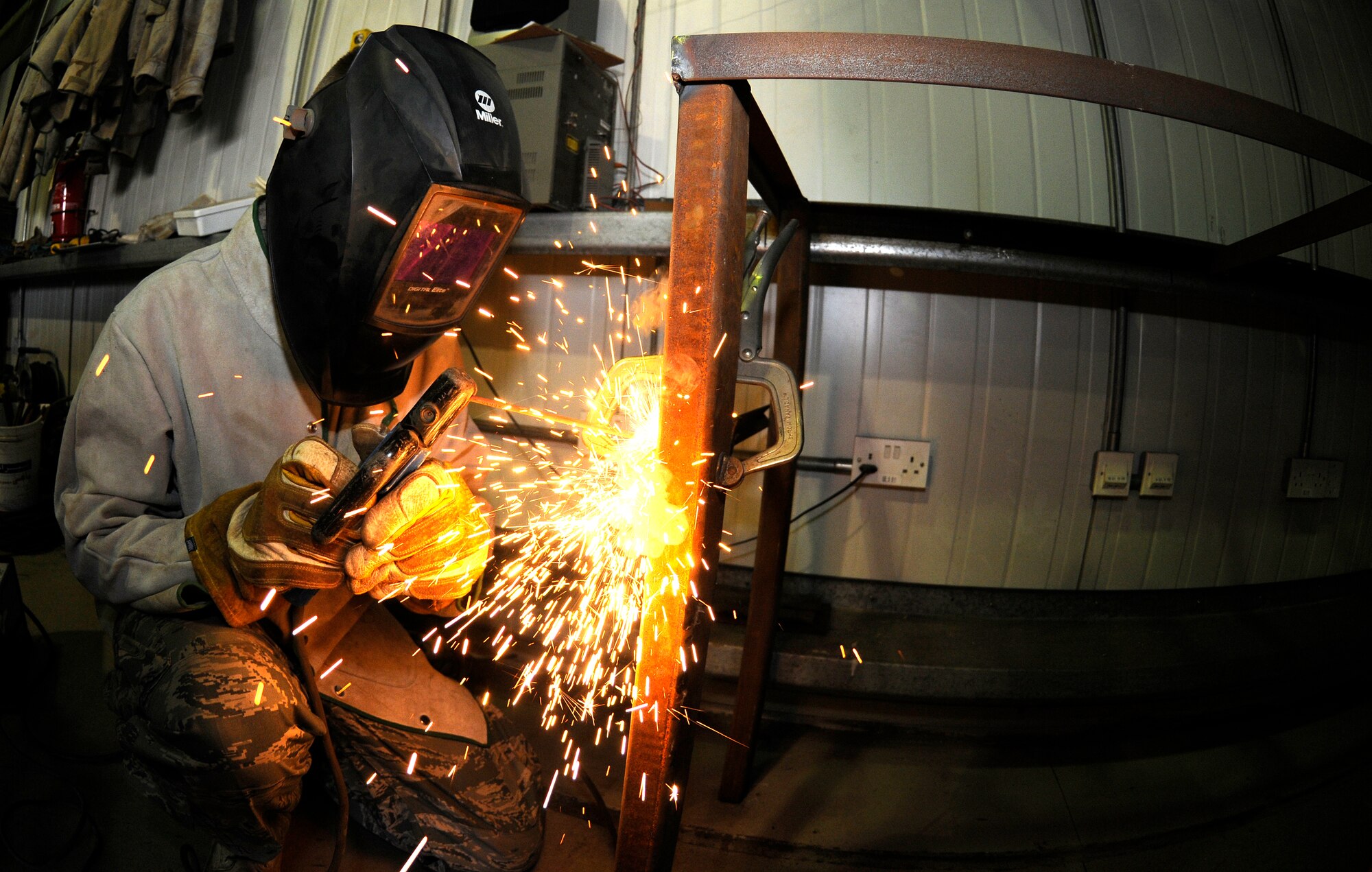 SOUTHWEST ASIA--Airman 1st Class Mack Carter from the 380th Expeditionary Civil Engineer Squadron, uses an arc welder on a brace here. He is welding a brace to a new work bench for the structures shop to increase work space and capabilities. Airman Carter is deployed from the 735th Civil Engineer Squadron, Ramstein Air Base, Germany, his hometown is Sanford, N.C.(U.S. Air Force photo/Tech. Sgt. Christopher A Campbell)(released)