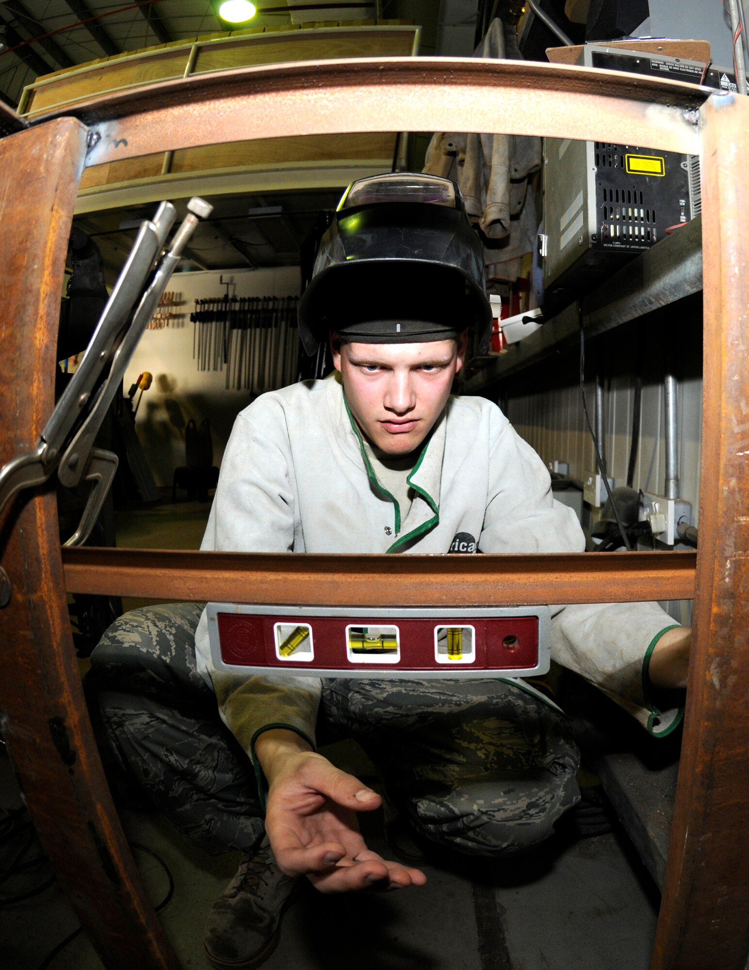 SOUTHWEST ASIA -- Airman 1st Class Mack Carter from the 380th Expeditionary Civil Engineer Squadron uses a torpedo level on a brace here. The brace will be welded onto a new work bench for the structures shop to increase work space and capabilities. Airman Carter is deployed from the 735th Civil Engineer Squadron, Ramstein Air Base, Germany, his hometown is Sanford, N.C. (U.S. Air Force photo/Tech. Sgt. Christopher A Campbell)(released)