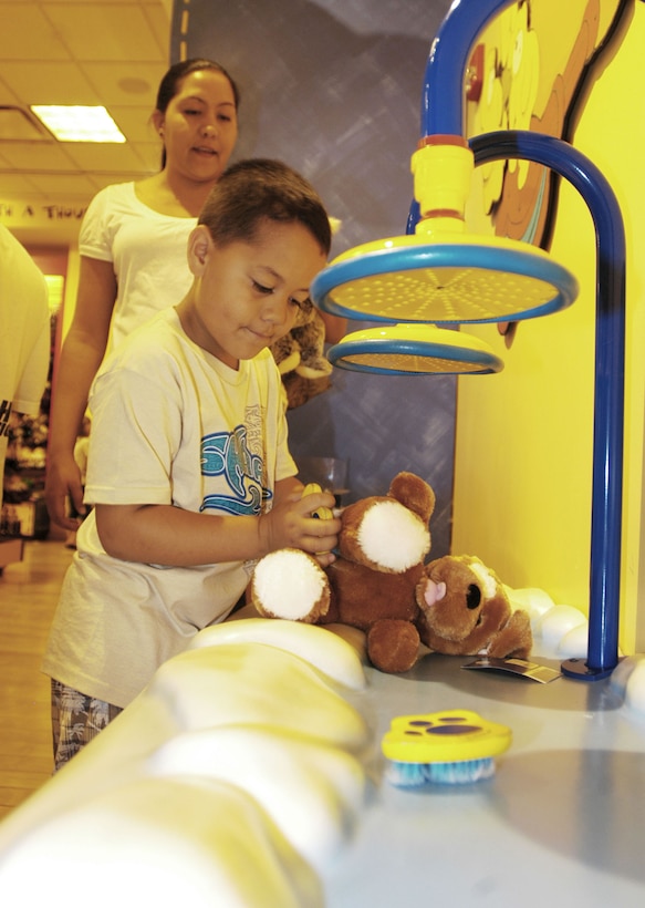 Kolaiah Joseph, 5, bathes a plush animal he created for donation to the Marine Corps Reserve's annual Toys for Tots campaign, as his mother, Somers Joseph watches on, at the Ala Moana Build-a-Bear Workshop Nov. 15. According to Gunnery Sgt. Chris Whitley, Toys for Tots coordinator, the campaign collected approximately 40 toys at the store over the weekend.