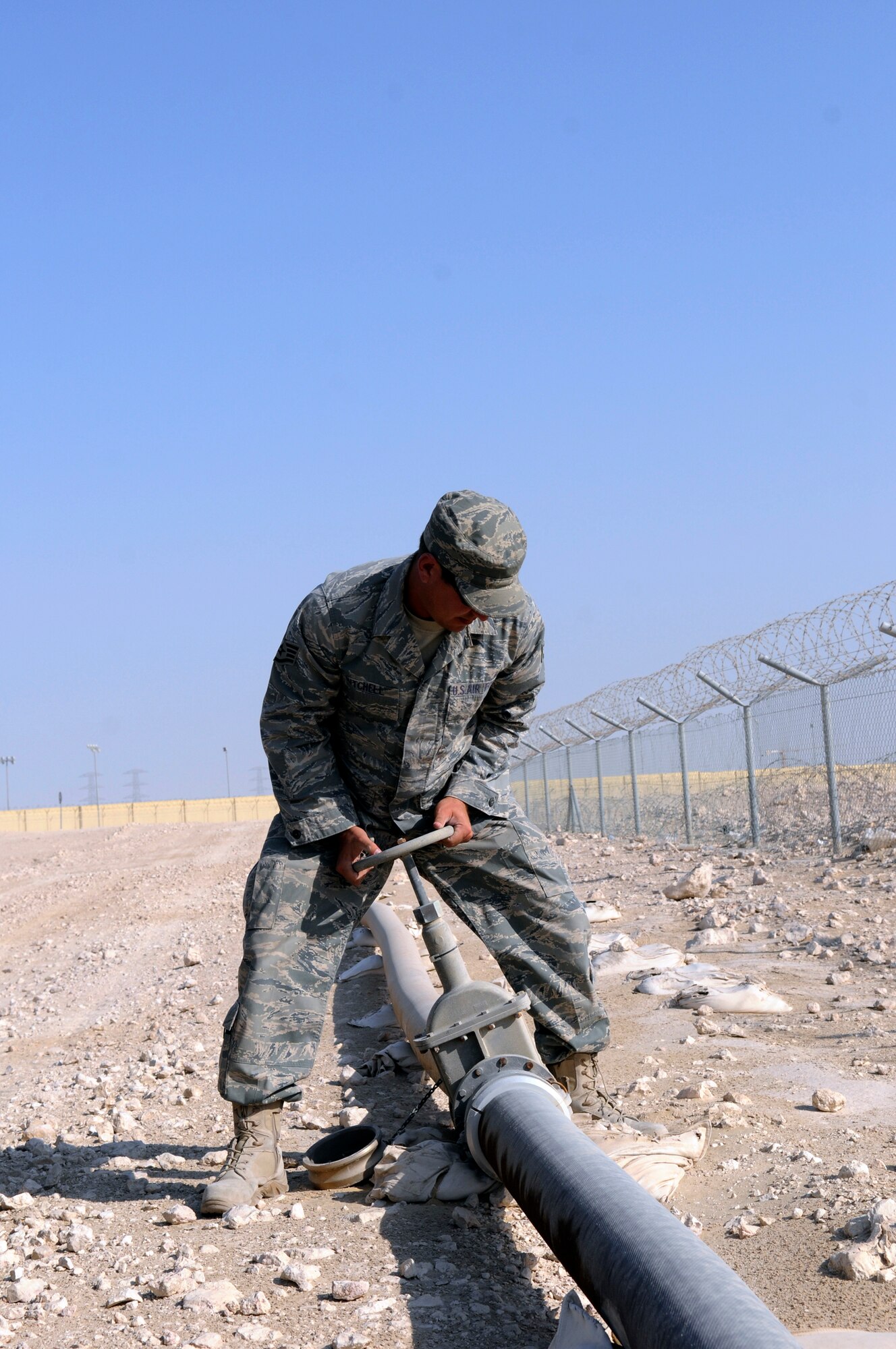 Staff Sgt. George Mitchell, fuels craftsman assigned to the 379th Expeditionary Logistics Readiness Squadron, straightens a gate valve that was laying on its side during a security and leak check of the fuel pipeline from bulk storage to operating storage, Nov. 14, at an undisclosed air base in Southwest Asia.  "Running the line" is a preventative procedure that keeps the fuel flowing to "fuel the fight."  Approximately one million gallons of fuel are moved each day through the 379 ELRS fuels section, keeping aircraft flying in Operations Iraqi and Enduring Freedom and Joint Task Force-Horn of Africa.  Sergeant Mitchell, a native of Lady Lake, Fla., is deployed from Shaw Air Force Base, S.C.  (U.S. Air Force Base photo by Tech. Sgt. Michael Boquette/Released)