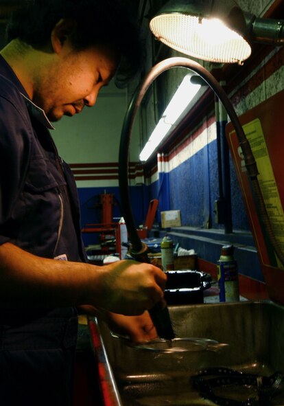 Mr. Yasushi Yokokawa, a mechanic at the Army & Air Force Exchange Service west side Auto Repair shop Yokota Air Base, Japan, cleans bolts used to hold on an oil pan Nov. 12. This is just one of the various services the auto repair shop offers.  Other services include oil checks and changes, brake diagnostics and  battery replacements. (U.S. Air Force photo by Airman 1st Class Michael Dillon)