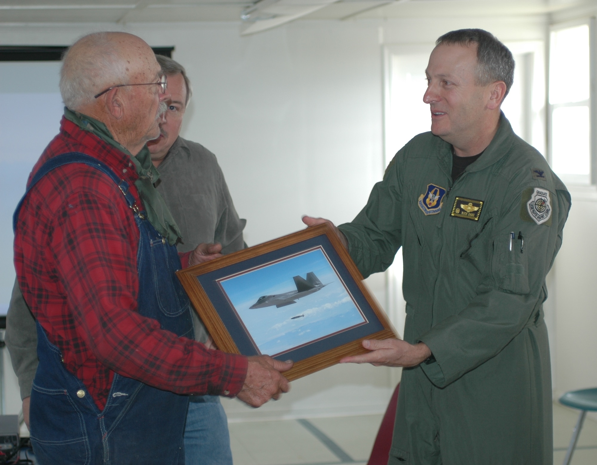 Reserve 419th Fighter Wing Commander, Col. Walter Sams, presents a photo of fighter aircraft operations on the Utah Test and Training Range to Mr. Cecil Garland, a resident of Callao, Utah, during the Moses Tour Nov. 6.  The outreach event is led by the 388th Range Squadron each fall to strengthen understanding of and support for the Air Force mission in communities underlying the UTTR. (U.S. Air Force photo)