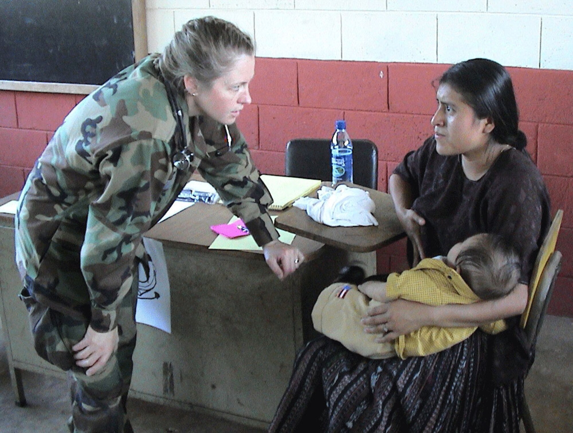 Lt. Col. (Dr.) Colleen Kelley talks with a mother during the colonel's deployment to Guatemala. Colonel Kelley is the chief of flight medicine with the 439th Aerospace Medicine Squadron. A reservist from Vermont, she spent two weeks in Guatemala in 2005, treating patients in remote clinics with the 710th Medical Squadron from Omaha, Neb. Two years later, she was part of a combined medical missionary mission to Bizerte, Tunisia, at Kharouba Air Base, where she trained with the Tunisian military, teaching aeromedical transport concepts. (Courtesy photo)