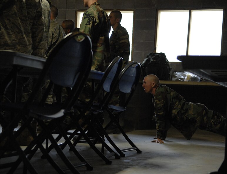MOODY AIR FORCE BASE, Ga. -- An Airman performs push-ups during an early morning briefing to help him stay awake through out ranger candidate training here Nov. 13. Airmen from Moody AFB and other military installations entered their fourth day of a preparatory course offered by the 820th Security Forces Group.  (U.S. Air Force photo by Senior Airman Javier Cruz)
