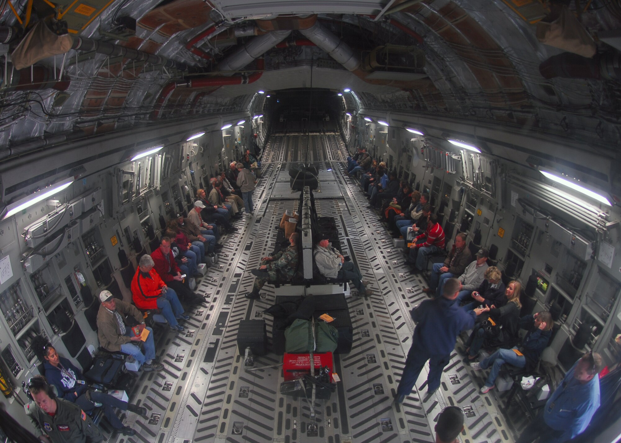 Members of the Altus, OK community prepare for a Farm/City Tour flight on board a C-17. During the flight, passengers were given the chance to see the aircraft being refueled by a KC-135, a pallet drop, and, with the assistance of Loadmaster SMSgt Brian Williams of the 58th Airlift Squadron, the C-17 going in reverse while grounded.  (U.S. Air Force photo/Senior Airman Amanda M. Bower)