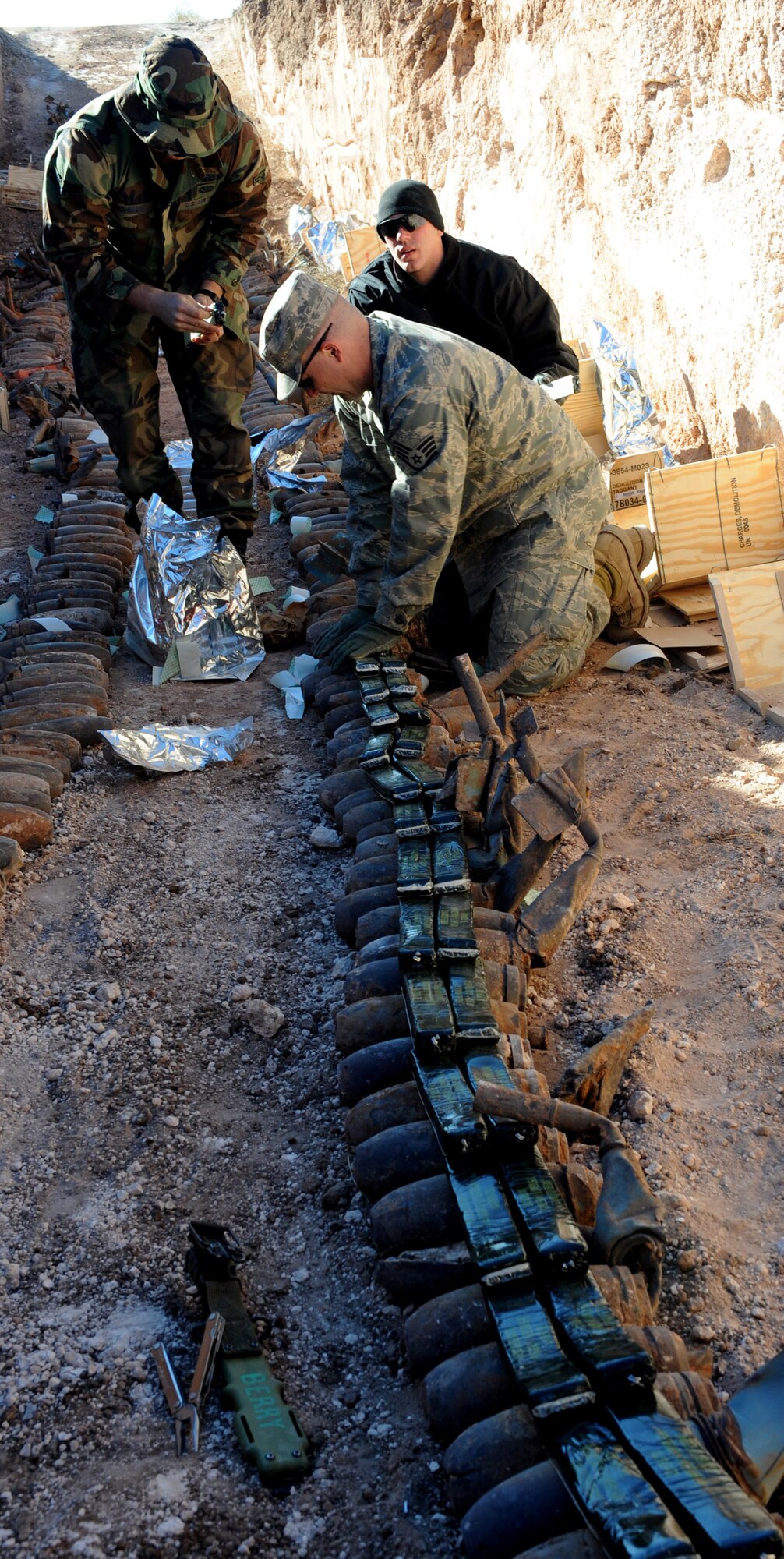 CANNON AIR FORCE BASE, N.M. -- (left to right) Airman 1st Class Steve Zachman, Staff Sgt. David Hewitt, and Airman 1st Class Nathan Baloga, 27th Special Operations Civil Engineer Squadron's Explosive Ordnance Disposal flight plant demolition charges Nov 6. The EOD team were performing their yearly ordnance clearing at Melrose Air Force Range. (U.S. Air Force photo/Airman 1st Class Evelyn Chavez)
