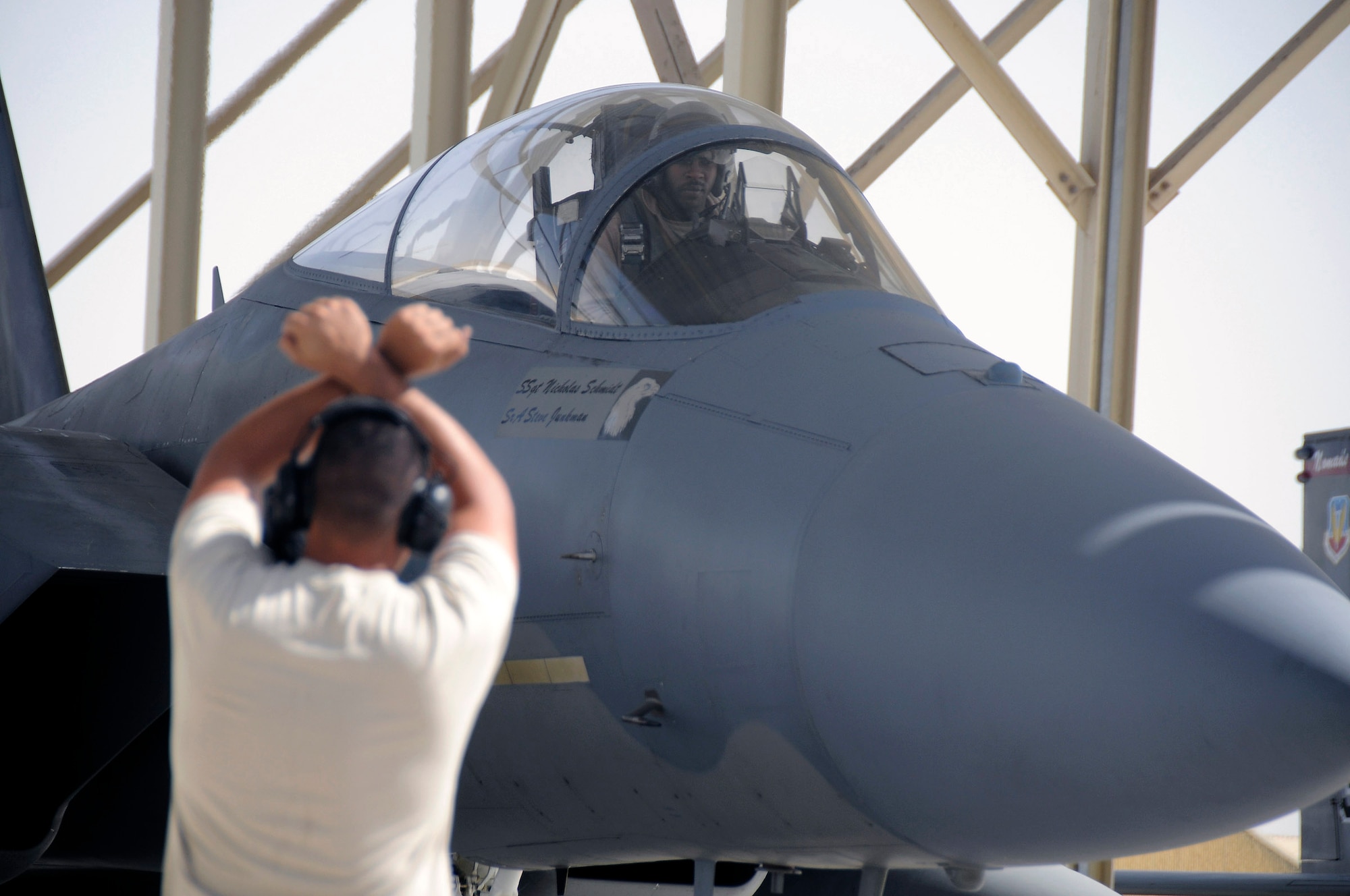Capt. Rick Jones looks to Staff Sgt. Mike Membrilla for directions to safely maneuver his F-15 Eagle onto the runway Nov. 13 at an air base in Southwest Asia. Captain Jones and Sergeant Membrilla are members of the 58th Fighter Squadron from Eglin Air Force Base, Fla. They are deployed here in support of a multinational exercise. (U.S. Air Force photo/Tech. Sgt. Christopher A. Campbell)
