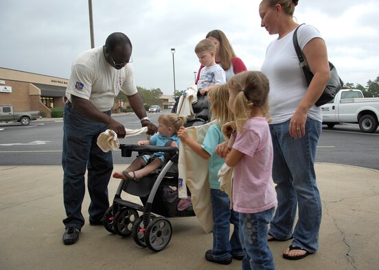 MOODY AIR FORCE BASE, Ga. -- Elvis Lane, 23rd Civil Engineer Squadron environmental specialist, passes out T-shirts to Moody family members in support of America Recycles Day here Nov. 14. Mr. Lane also provided information to Team Moody on the benefits of recycling. (U.S. Air Force photo by Senior Airman Elizabeth Rissmiller) 