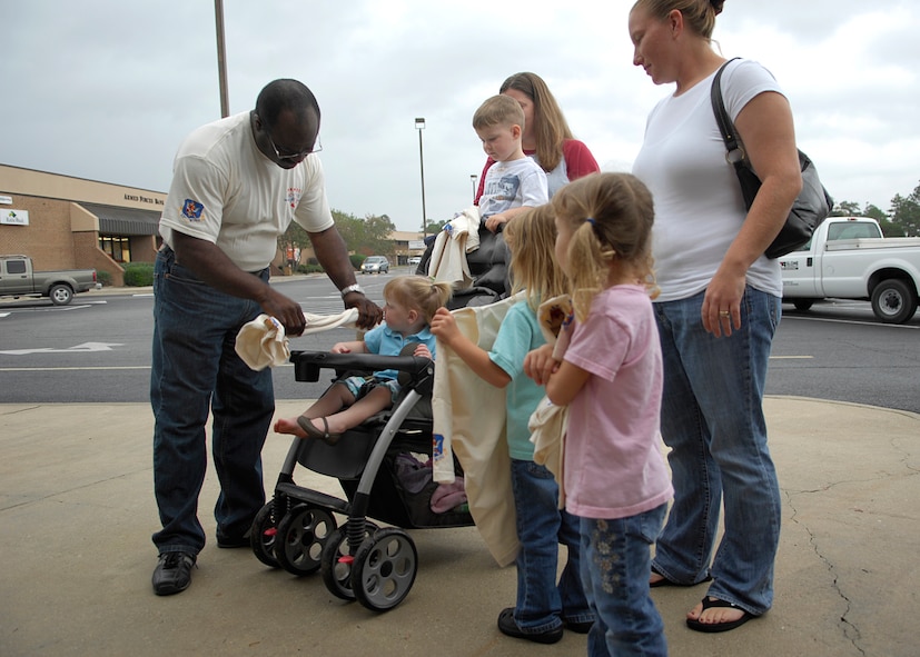 MOODY AIR FORCE BASE, Ga. -- Elvis Lane, 23rd Civil Engineer Squadron environmental specialist, passes out T-shirts to Moody family members in support of America Recycles Day here Nov. 14. Mr. Lane also provided information to Team Moody on the benefits of recycling. (U.S. Air Force photo by Senior Airman Elizabeth Rissmiller) 