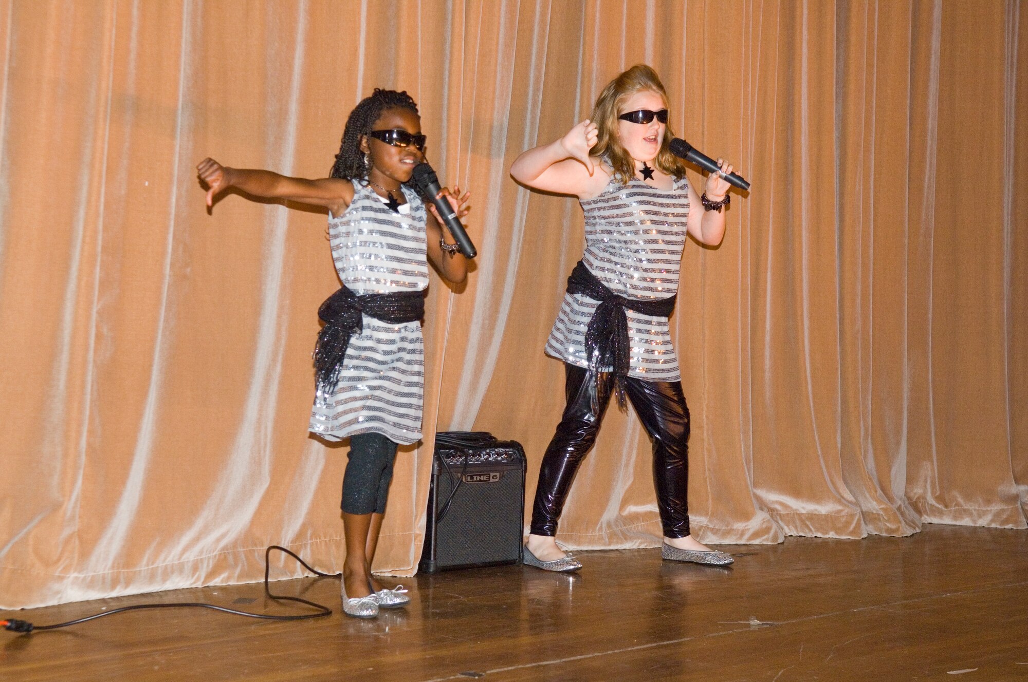 HANSCOM AIR FORCE BASE, Mass. – Adrienne Austin and Whitney Evans perform a song and dance routine during the 66th Services Squadron’s talent contest at the Base Theater on Nov. 13. The talented duo went on to capture first place in their age category, other first place winners included: Colin Canavan; Sidney Pandes; and Tamala, Ytrenda and Brenda Gulley in the parent and youth team category. (U.S. Air Force photo by Rick Berry)