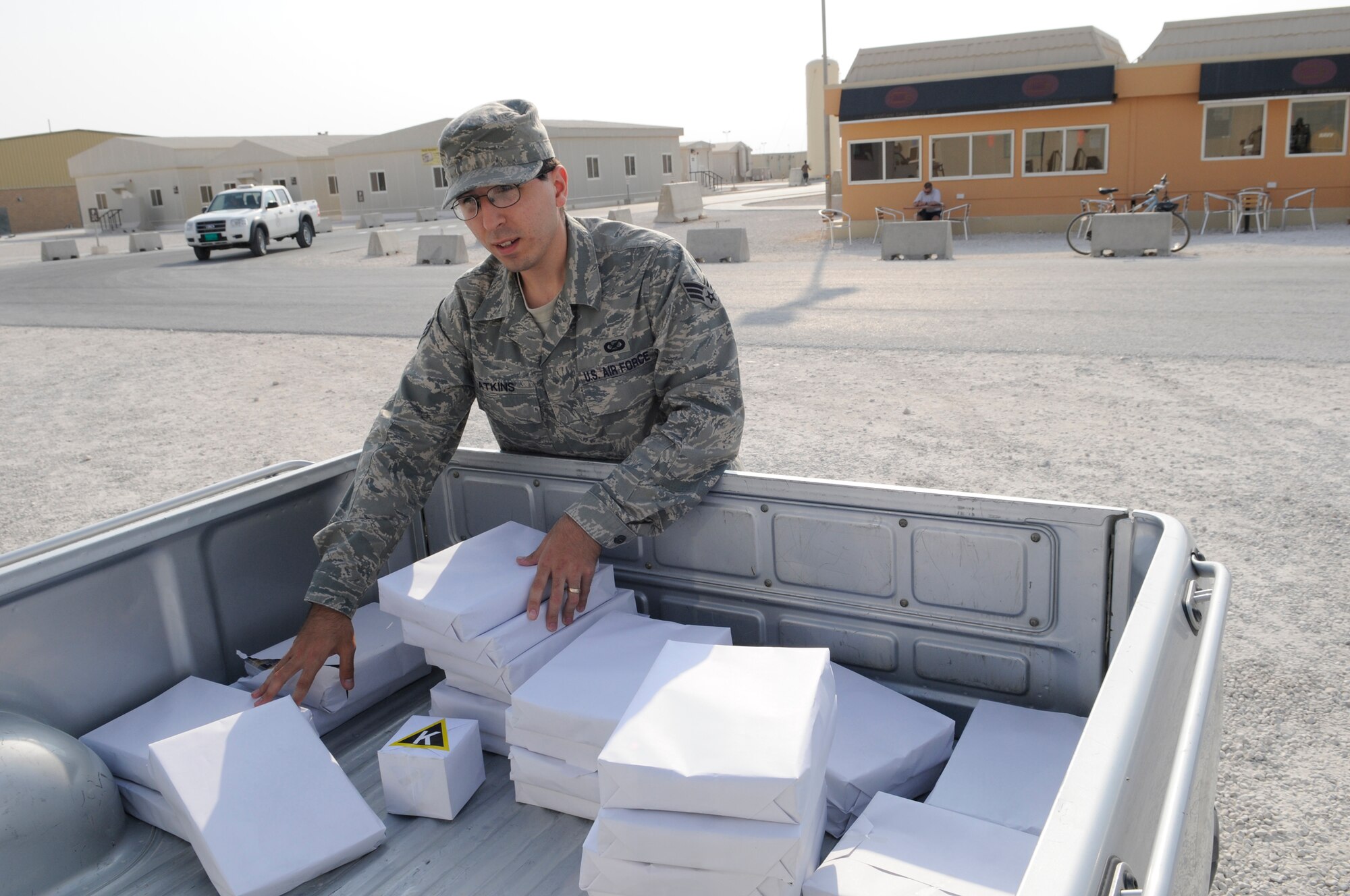 Senior Airman Clinton Atkins, journalist assigned to the 379th Air Expeditionary Wing, gathers bundles of freshly printed Desert Eagle news magazines for delivery to the Learning Resource Center, Nov. 16, at an undisclosed air base in Southwest Asia. The Desert Eagle magazine keeps deployed members abreast of the latest happenings and is a primary communication tool for the 379 AEW commander. Airman Atkins, a native of San Antonio, Texas, is deployed from Altus Air Force Base, Okla., in support of Operations Iraqi and Enduring Freedom and Joint Task Force-Horn of Africa. (U.S. Air Force photo by Tech. Sgt. Michael Boquette/Released)
