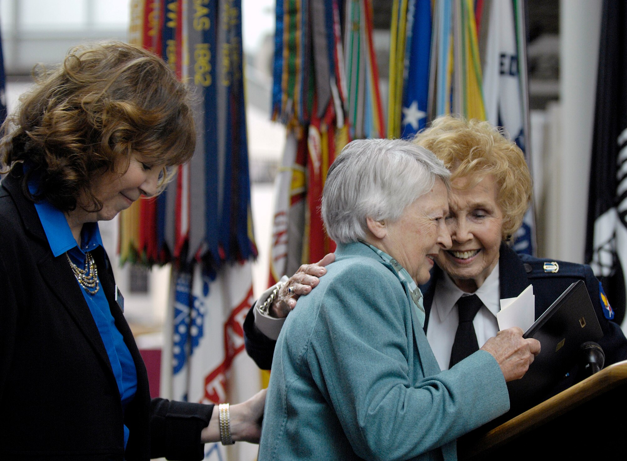 Nancy Parrish (left), director of Wings Across America, enjoys the moment as retired Brig. Gen. Wilma Vaught receives a gift from Deanie Parrish, a World War II Women Airforce Service Pilot, during the "Fly Girls of World War II" exhibit which opened in their honor Nov. 14 at the Women in Military Service for America Memorial in Arlington, Va.  Approximately 25 WASPs attended the opening ceremony.  WASPs were the first U.S. military-trained women aviators in history.  (U.S. Air Force photo/Scott M. Ash)