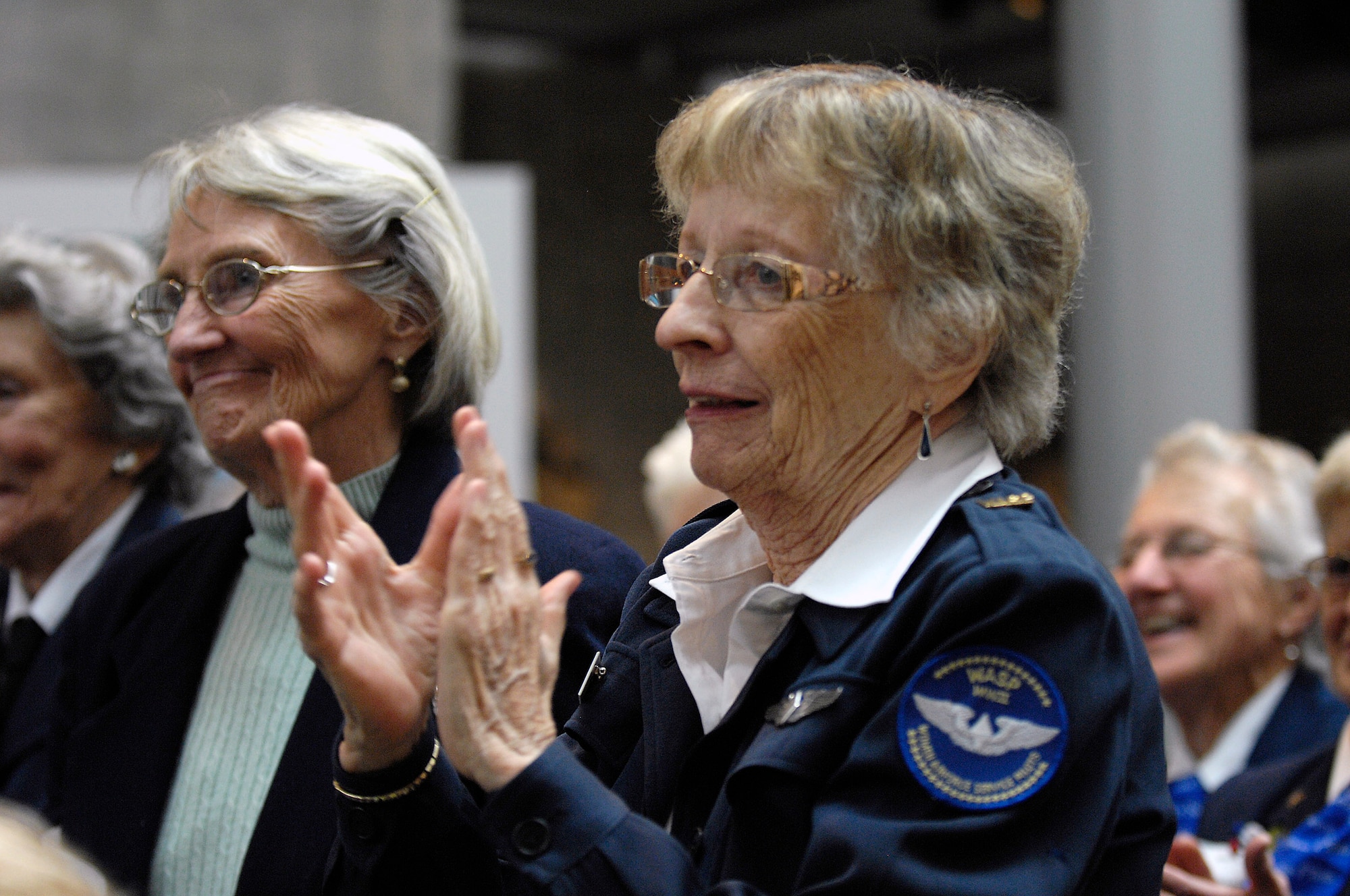 Mary Cox and Kris "Swan" Lent, World War II Women Airforce Service Pilots  applaud a speaker while attending the "Fly Girls of World War II" exhibit which opened in their honor Nov. 14 at the Women in Military Service for America Memorial in Arlington, Va.  Approximately 25 WASPs attended the opening ceremony.  WASPs were the first U.S. military-trained women aviators in history.  (U.S. Air Force photo/Scott M. Ash)
