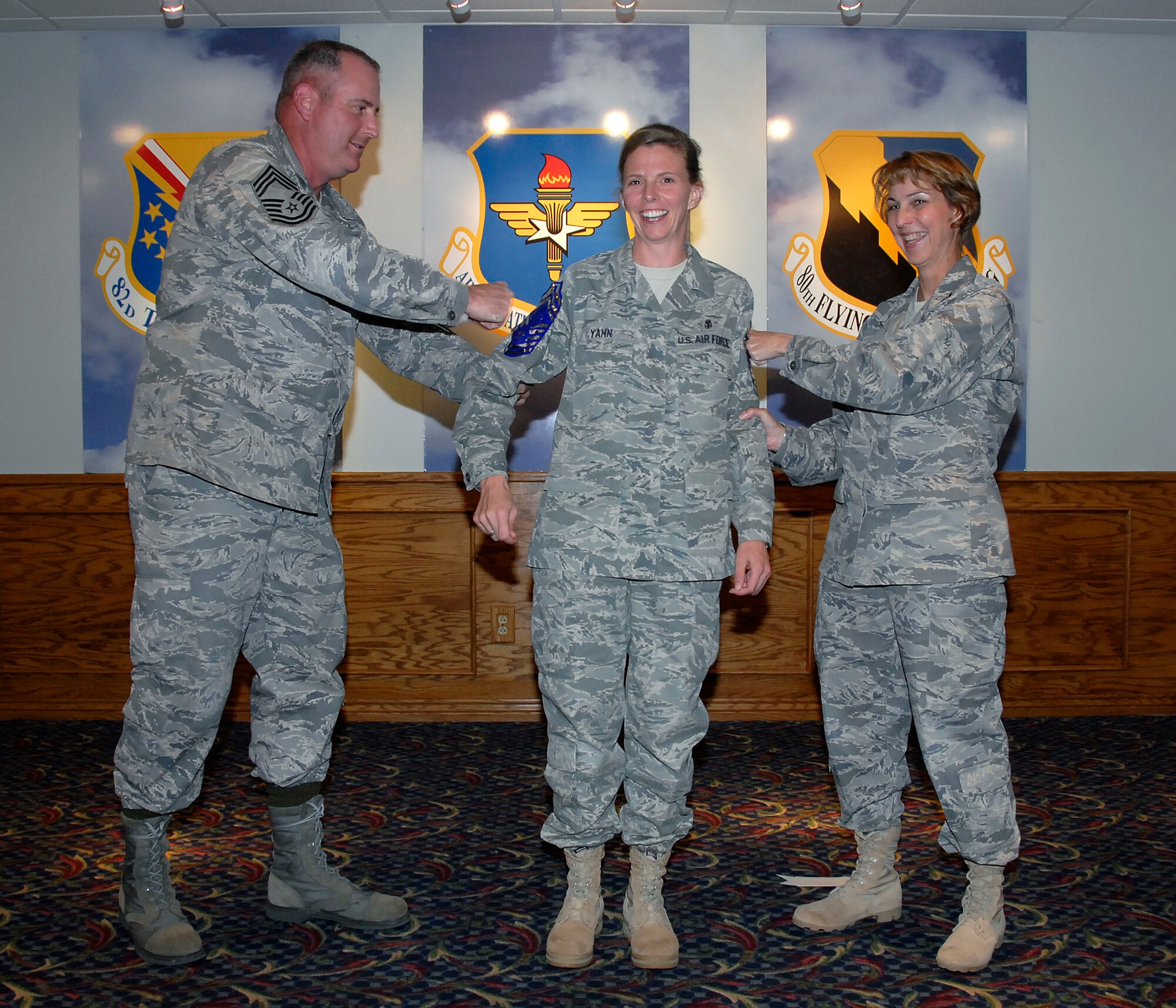 Chief Master Sgt. Wayne Bishop, left, and Col. Janice Wallace, deputy commander of the 82nd Medical Group, tack on a set of chief master sergeant chevrons to the arm of Senior Master Sgt. Tanya Yahn Nov. 14 during a promotion party at the Sheppard Club. Sergeant Yahn was among four Team Sheppard members selected for promotion to E-9. (U.S. Air Force photo/Mike Litteken)