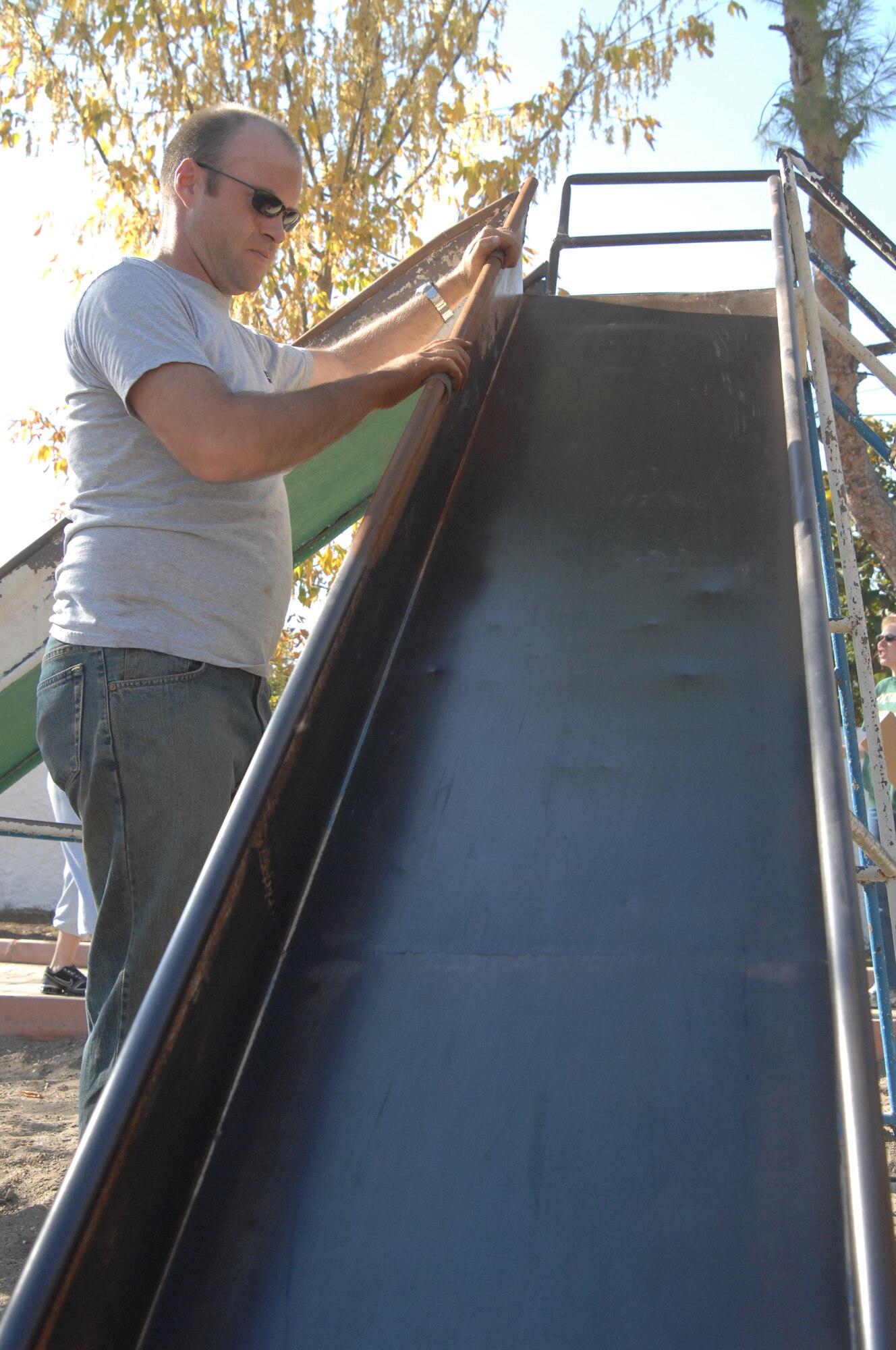 Staff Sgt. Christopher Self, 39th Logistics Readiness Squadron, sands rust off a slide at an Incirlik Village park, Nov 15. Sergeant Self was among the estimated 60 volunteers present who helped the Incirlik Air Base Chapel renovate the park in an effort to strengthen community relations. (U.S. Air Force photo by Senior Airman Benjamin Wilson)
