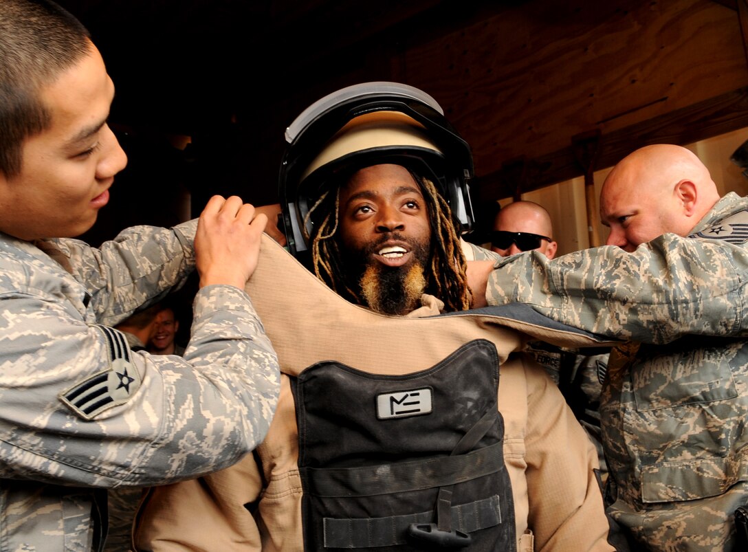 Rapper Kaine of the duo The Ying Yang Twins tries on a bomb disposal suit during a visit to Bagram Air Base, Afghanistan, Nov. 14, 2008. The rappers are on an eight-day USO tour with Vice Chairman of the Joint Chiefs of Staff U.S. Marine Gen. James E. Cartwright.