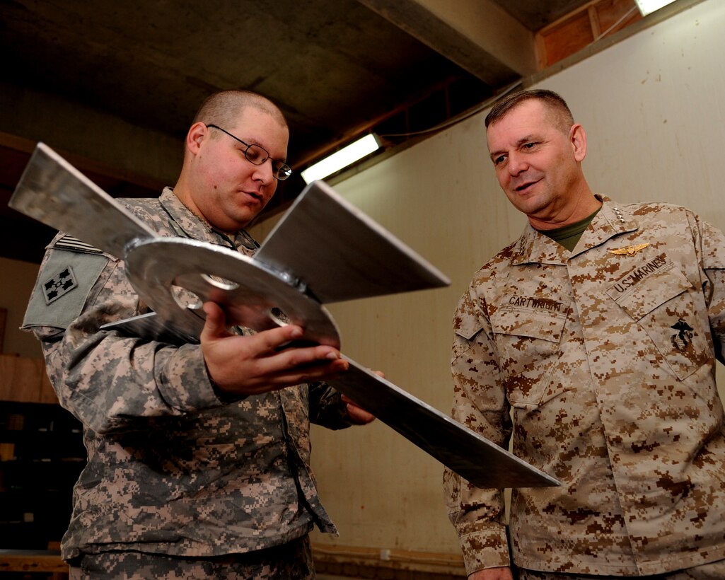 U.S. Army Chaplain (Capt.) Matthew Guncheon shows Vice Chairman of the Joint Chiefs of Staff U.S. Marine Gen. James E. Cartwright a cross at the chapel at Combat Outpost Summers, Iraq, Nov. 15, 2008. The cross was made out of scrap metal by U.S. Army Spc. Daniel Bristow and Cpl. Meral Smith.