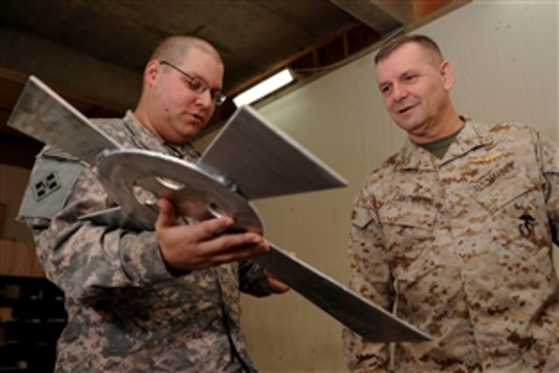 U.S. Army Chaplain (Capt.) Matthew Guncheon shows Vice Chairman of the Joint Chiefs of Staff U.S. Marine Gen. James E. Cartwright a cross at the chapel at Combat Outpost Summers, Iraq, Nov. 15, 2008. The cross was made out of scrap metal by U.S. Army Spc. Daniel Bristow and Cpl. Meral Smith. 