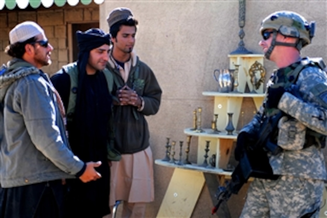 U.S. Army Cpl. Matt Andrews talks with actor "shopkeepers" in Madina Wasl, a simulated city at the National Training Center in Fort Irwin, Calif., Nov. 8, 2008,The National Training Center provides soldiers with pre-deployment training, combat skills and maneuvers vital for survival during their time abroad. Andrews is an assistant team leader with the 25th Infantry Division's 4th Brigade Combat Team.