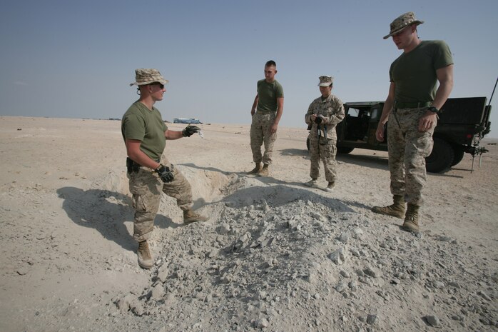 Sgt. Curtis Long, an explosive ordnance disposal technician with the 26th Marine Expeditionary Unit, explains how, why and what to expect in a crater formed by an explosion to (from left) Lance Cpl. Anthony Larchergore, Capt. Joni Ong and Lance Cpl. Charles Wiggins, at a training site in the Middle East, Nov. 18, 2008. The MEU's EOD Marines safely cleared hundreds of pounds of unexploded ordnance that was found on a range, which was later to be used by the MEU's Ground Combat Element, Battalion Landing Team 2/6, for training.