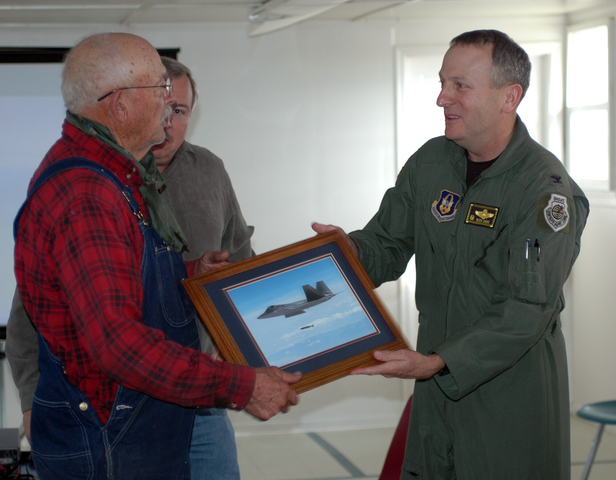 Col. Walter Sams, 419th Fighter Wing commander, presents a photo of fighter aircraft operations on the Utah Test and Training Range to Mr. Cecil Garland, a resident of Callao, Utah, during the Moses Tour Nov. 6. The outreach event is led by the 388th Range Squadron each fall to strengthen understanding of and support for the Air Force mission in communities surrounding the UTTR. (U.S. Air Force photo)  