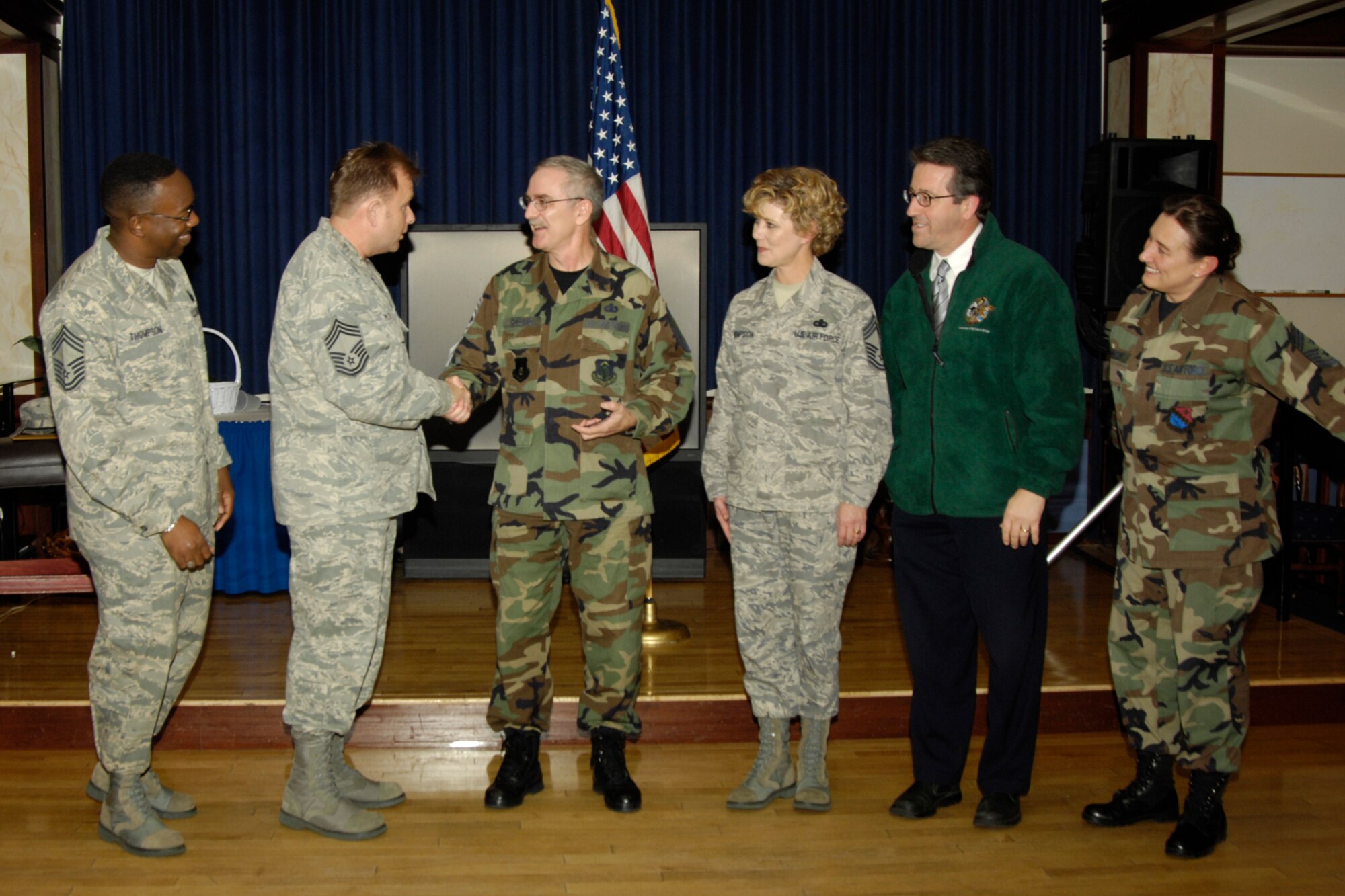 HANSCOM AIR FORCE BASE, Mass. – Senior Master Sgt. Stan Holland (second from left), is congratulated on his selection for promotion to the rank of Chief Master Sergeant at the Minuteman Club on Nov. 12. Offering their congratulations and welcoming Sergeant Holland to the rank of Chief are (left to right), Chief Master Sergeants’ Al Thompson, Michael McCoy, Ginger Thompson, Michael Boudreau (retired), and Karen McCoy, ESC command chief master sergeant. (U.S. Air Force photo by Linda LaBonte Britt)