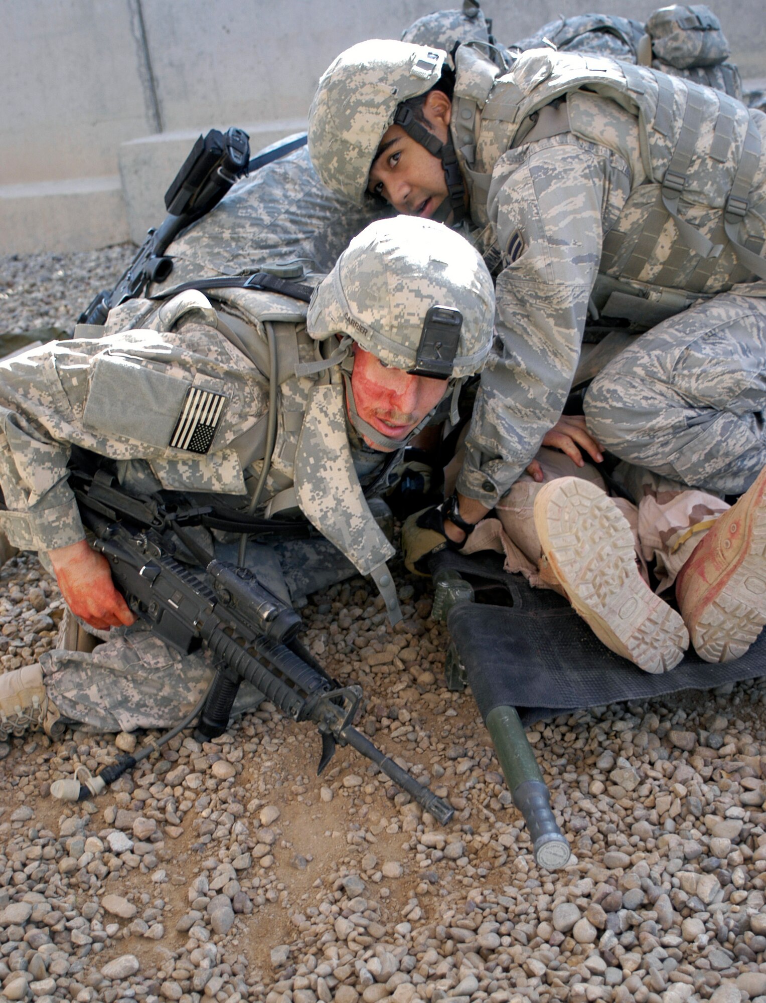 Airman 1st Class Jonathan Guzman covers a roleplayer who was simulated wounded to protect him from further injury during a counter attack during training Nov. 12 at Joint Base Balad, Iraq. Airman Guzman is a security forces apprentice deployed from Lackland Air Force Base, Texas, attended combat lifesaver training, which is a requirement for personnel in the 332nd Expeditionary Security Forces Group. He is assigned to the 532nd Expeditionary Security Forces Squadron. (U.S. Air Force photo/Tech. Sgt. Craig Lifton)                          