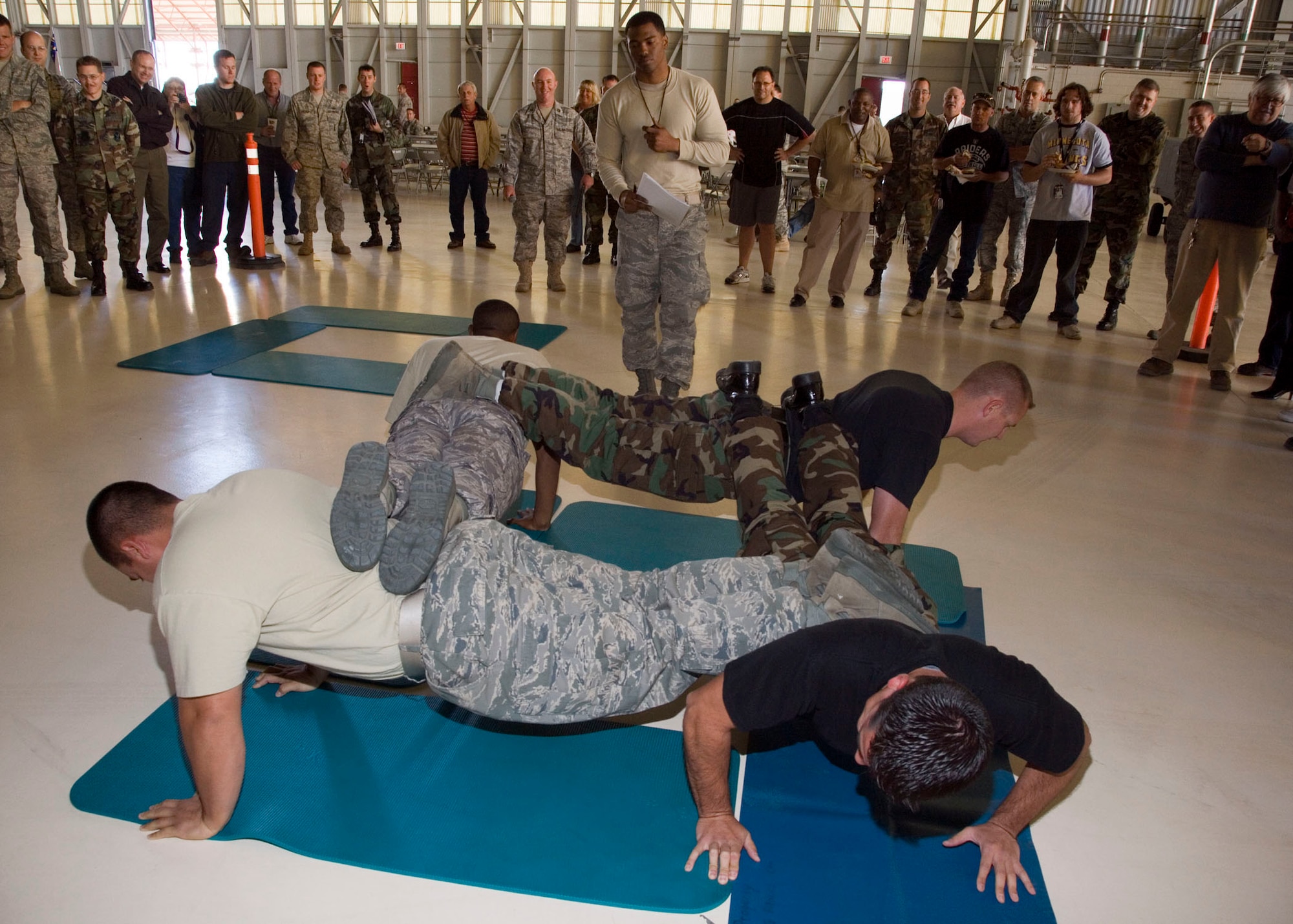 Maintainers perform team push-ups as part of the 412th Maintenance Group's first Maintenance Olympics at hangar 1600 Nov. 7. This was part of 412th MXG's and 31st Test and Evaluation Squadron's Wingman Day event. (Air Force photo by Chad Bellay)