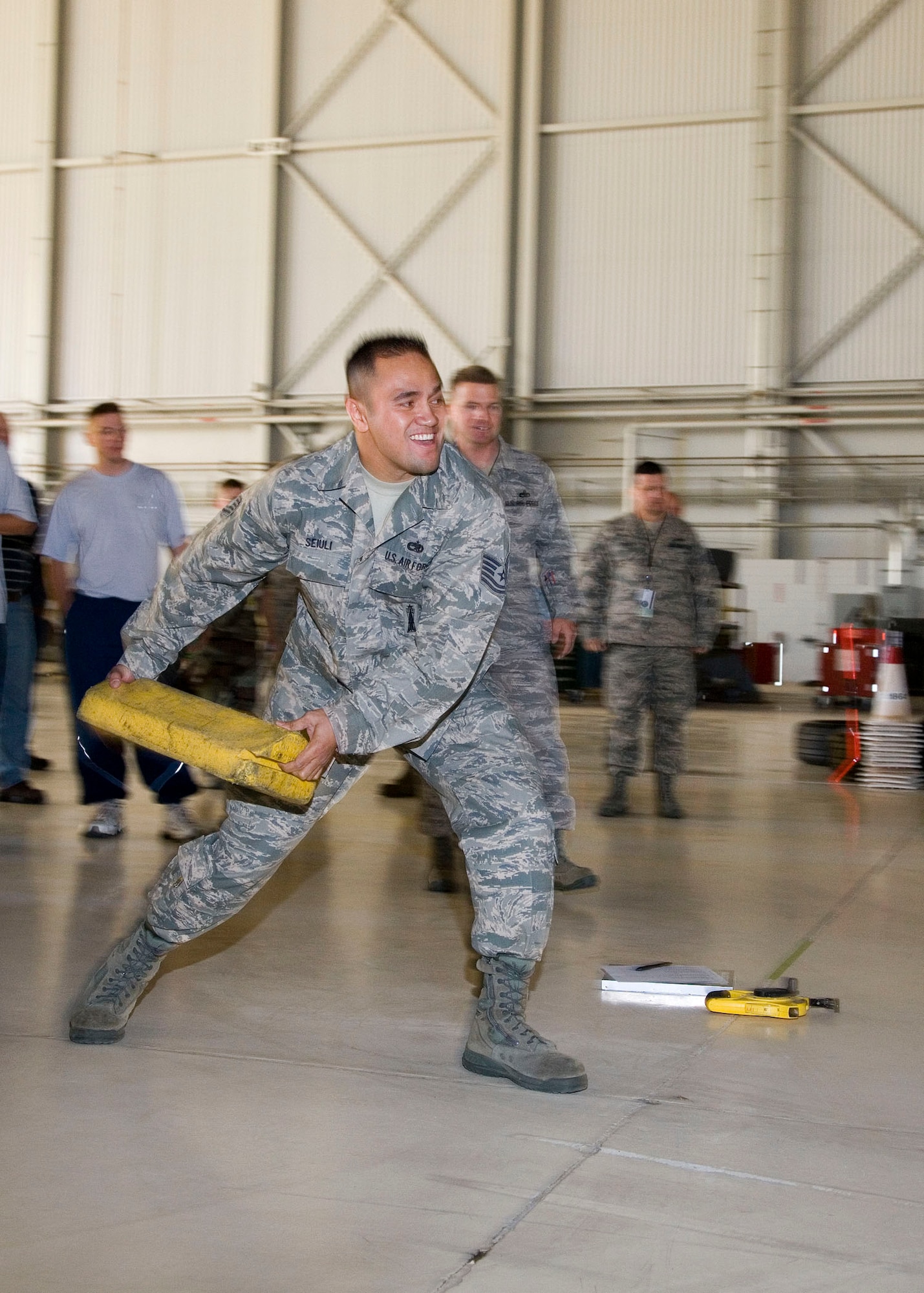 Tech. Sgt. Joseph Seiuli, 412th Maintenance Group aircraft armament systems specialist, tosses a chock as part of the 412th MXG's first Maintenance Olympics at hangar 1600 Nov. 7. Airmen and civilians from the 412th MXG and 31st Test and Evaluation Squadron participated in the event. (Air Force photo by Chad Bellay)