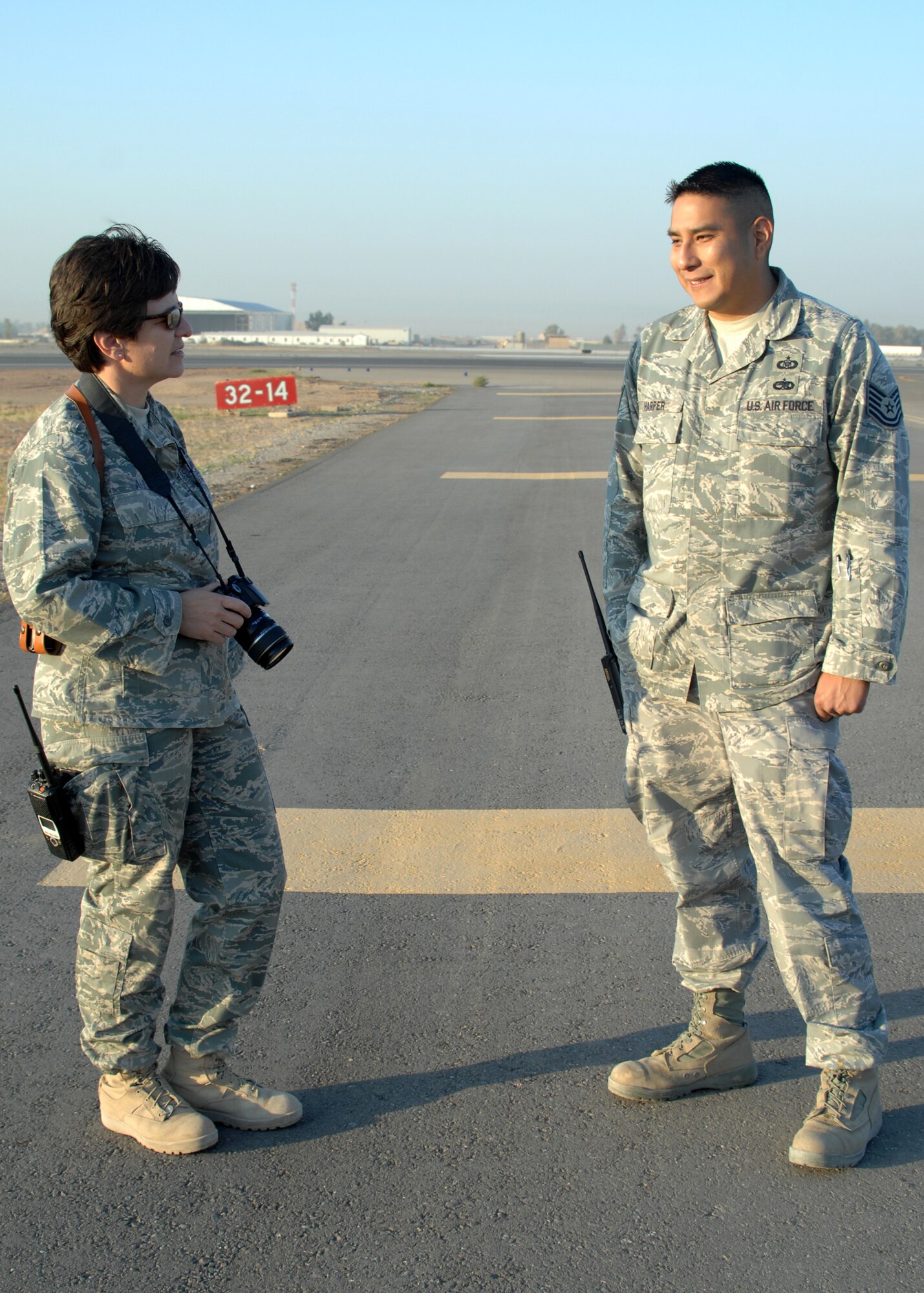 Lt. Col. Elisabeth Auld, 506th Expeditionary Operational Support Squadron commander and Tech. Sgt. Clint Harper, 506th EOSS airfield manager, talk about a couple of the small task to be completed on the new resurfaced runway 14/32 at Kirkuk Regional Air Base, Iraq, Nov. 17.  The 8,535-foot runway was re-opened after three months of work by RED HORSE and local civil engineer teams. (U.S. Air Force photo/ Master Sgt. Andrew Leonhard)