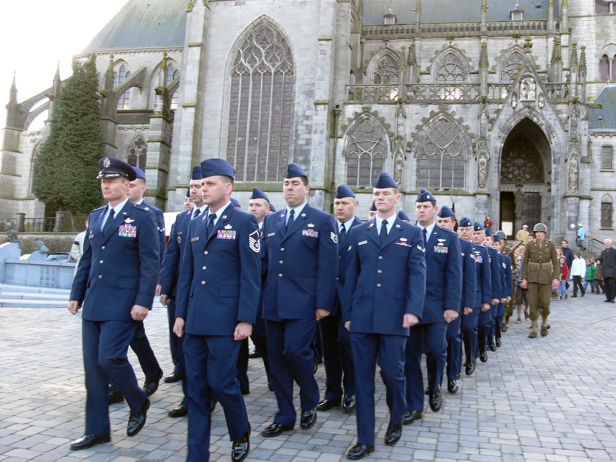 A 30-person USAFE contingent from the Warrior Prep Center and the Tactical Leadership Program in Florennes, Belgium, march in a short parade from the Basilica of Our Lady in Walcourt to a small cemetery following Mass. The parade included several local townspeople dressed in period costumes to honor the contributions of all who fought in World War I and World War II. (Courtesy photo)
