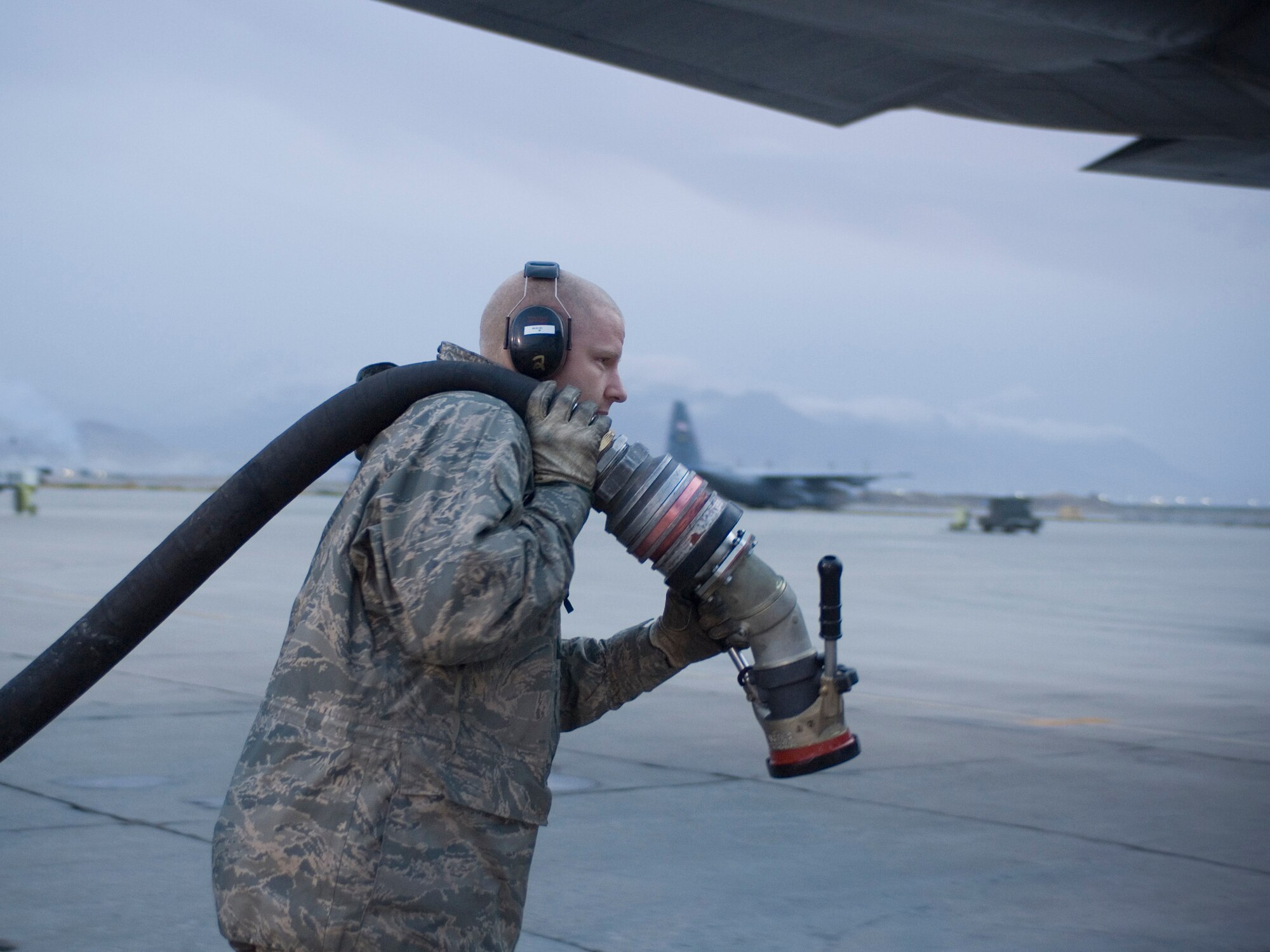 Staff Sgt. Michael Baker, 455th Expeditionary Logistics Readiness Squadron fuels specialist, pulls a fuel hose to a waiting aircraft at Bagram Air Field, Afghanistan, Nov. 14, 2008. Sergeant Baker, deployed from Minot Air Force Base, N.D., is trying to break the record for most fuel pumped in a deployment rotation. (U.S. Air Force photo by Staff Sgt. Rachel Martinez/Released)