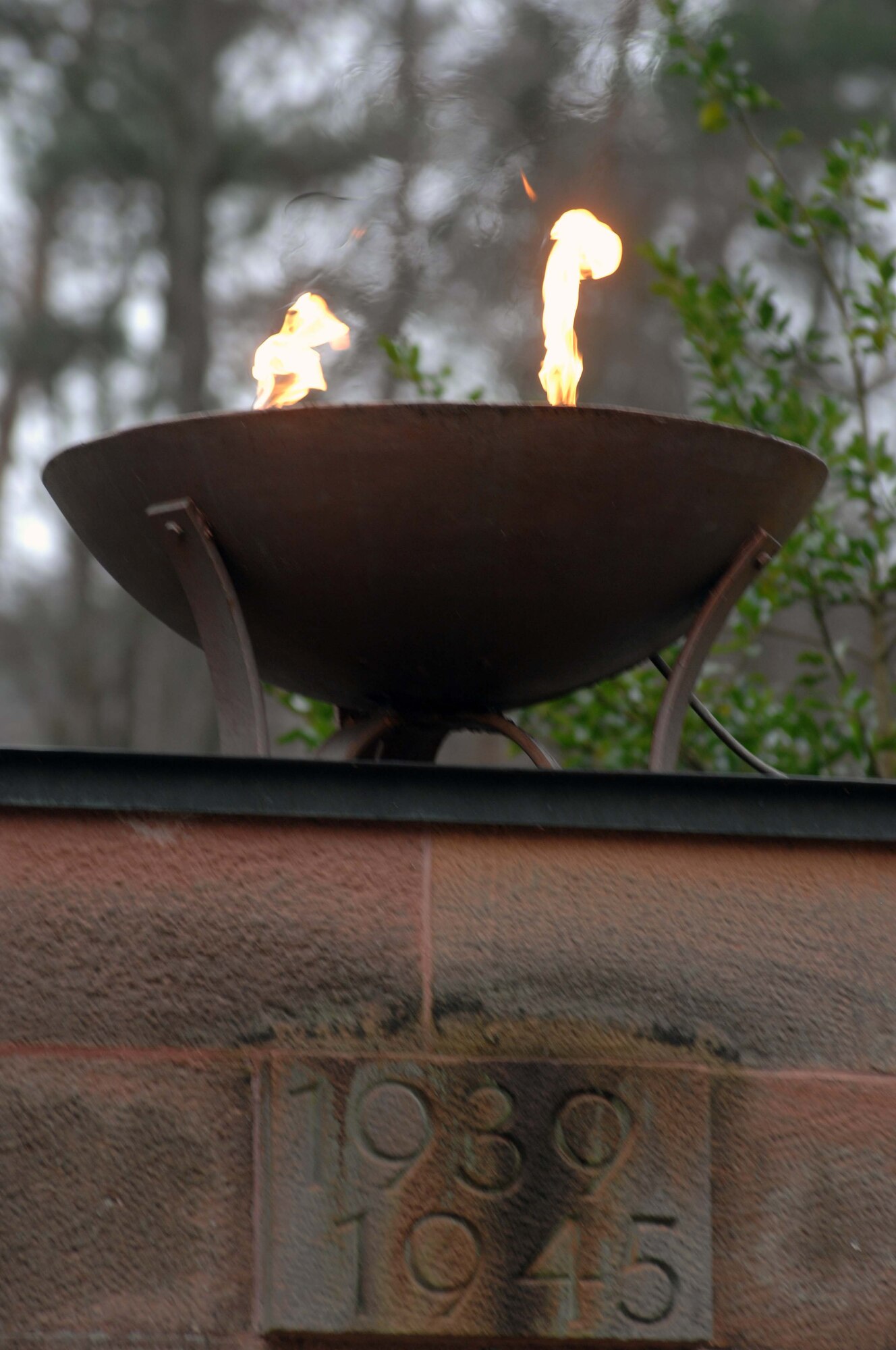 This eternal flame watches over military graves from World War II at the Soldiers' Monument in the Kaiserslautern Cemetery watches over military graves. More than 150 people from several different nationalities attended the German National Day of Mourning ceremony held Sunday at the Soldiers' Monument. The National Day of Mourning or Volkstrauertag is a public holiday in Germany that is observed two Sundays before the first Advent - the Sunday that is in the period from Nov. 13 to 19. This German holiday is similar to the United States' "Veteran's Day," except that it commemorates all victims who died during wars. It was first observed in Germany in 1952. The city of Kaiserslautern and the German Association of War Graves have held the Volkstrauertag wreath-laying ceremony at the Soldiers’ Monument in the Kaiserslautern Cemetery for 25 years. The ceremony usually consists of about 10 wreath presentations, one of which is from the Kaiserslautern military community where an Airman and Soldier will present the wreath and alongside an Air Force and Army officers will render a salute. The U.S. Army Garrison Kaiserslautern has participated in this ceremony since it was established in 1992. With two eternal flames, the Soldiers’ Monument watches over military graves from World War I and World War II. U.S. Army photo by Christine June, USAG Kaiserslautern.

