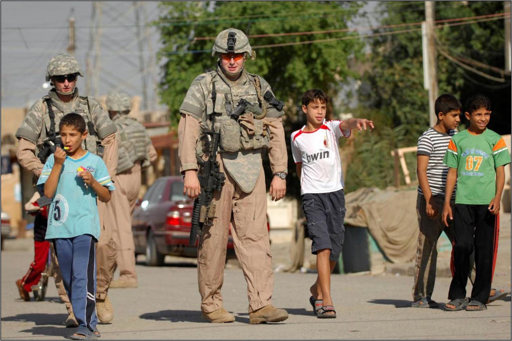Children swarm around Airmen from the 732nd Expeditionary Security Forces Squadron Detachment 3, who is attached to the 716th Military Police Battalion, 18th MP Brigade, during a Police Transition Team joint patrol with Iraqi police in the Al-Bayaa community of southern Baghdad Nov. 7. As security situations improve in the area, children and citizens are more comfortable to interact with both the IP and the coalition force police. (U.S. Navy photo/Petty Officer 2nd Class Todd Frantom)