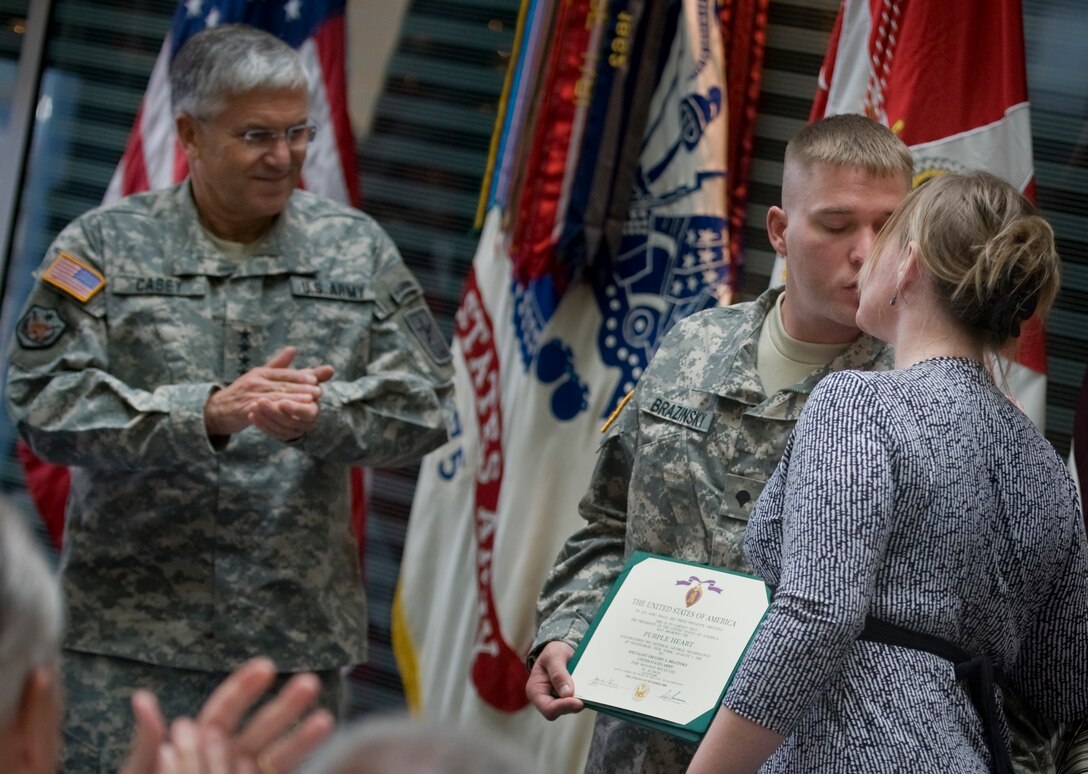 U.S. Army Spc. Gregory Brazinsky receives a kiss from his wife after he was presented the Purple Heart medal from Chief of Staff of the Army Gen. George W. Casey Jr., at the Center for the Intrepid, Fort Sam Houston, Texas, Nov. 17, 2008. Brazinsky was injured by an improvised explosive device on Aug. 10, 2008.