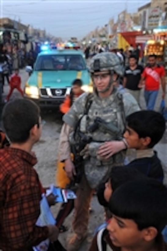 U.S. Air Force 1st Lt. Steven Benson speaks with Iraqi children during a patrol with Iraqi police in the Shurta Market of the Al-Bayaa district of Baghdad, Iraq, on Nov. 14, 2008.  The airmen are assigned to Detachment 3, 732nd Expeditionary Security Forces Squadron and are attached to the 1st Brigade Combat Team, 4th Infantry Division.  