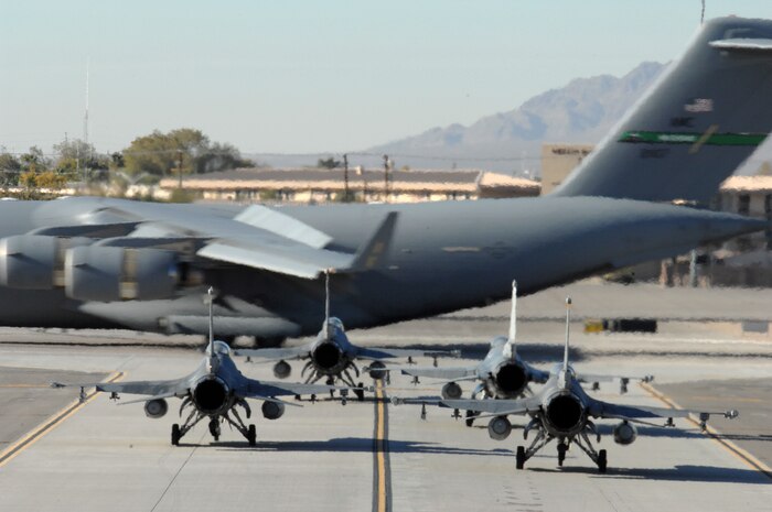 A C-17 Globemaster taxis past a group of F-16 during the Mobility Air Forces Exercise, MAFEX, Nov. 19, 2008, Nellis Air Force Base, Nev. Approximately twelve U.S. Air Force bases participate in MAFEX at the U.S. Air Force Weapons School twice a year, testing C-17 Globemasters and C-130 Hercules crews’ ability to join together in formation at a specific time and location to drop a brigade-size force anywhere in the world. (U.S. Air Force Photo by/Senior Airman Larry E. Reid Jr.)